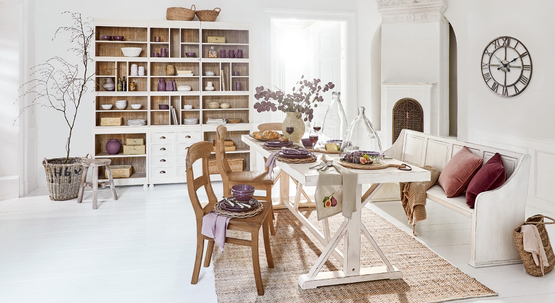 Rustikaler Essbereich mit weissem Holztisch und violetten Akzenten, natürliche Materialien und gemütliches Ambiente