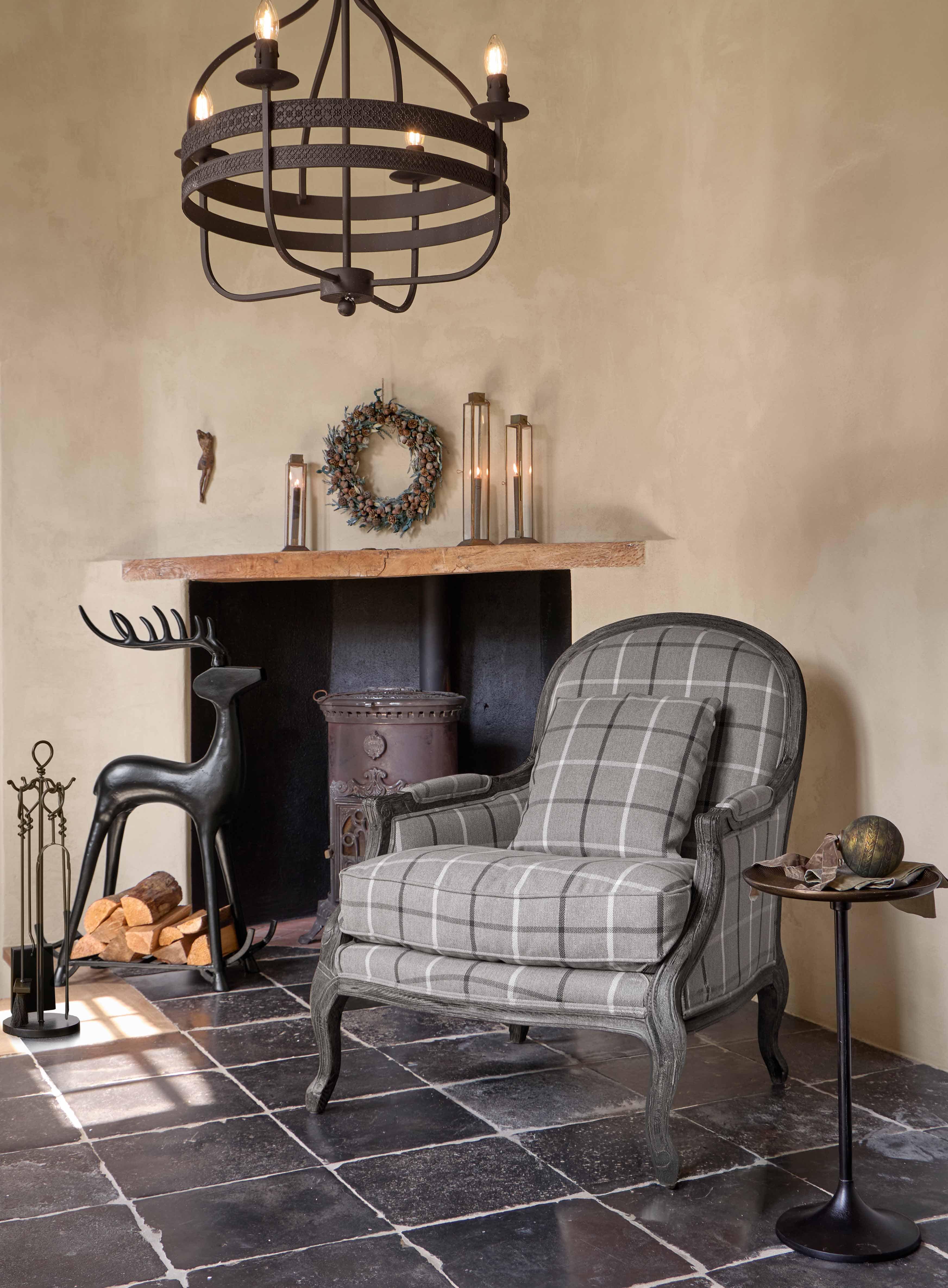 Grauer kariertes Polsterfauteuil mit Holzrahmen im klassischen Stil in gemütlichem Wohnzimmer mit Kamin