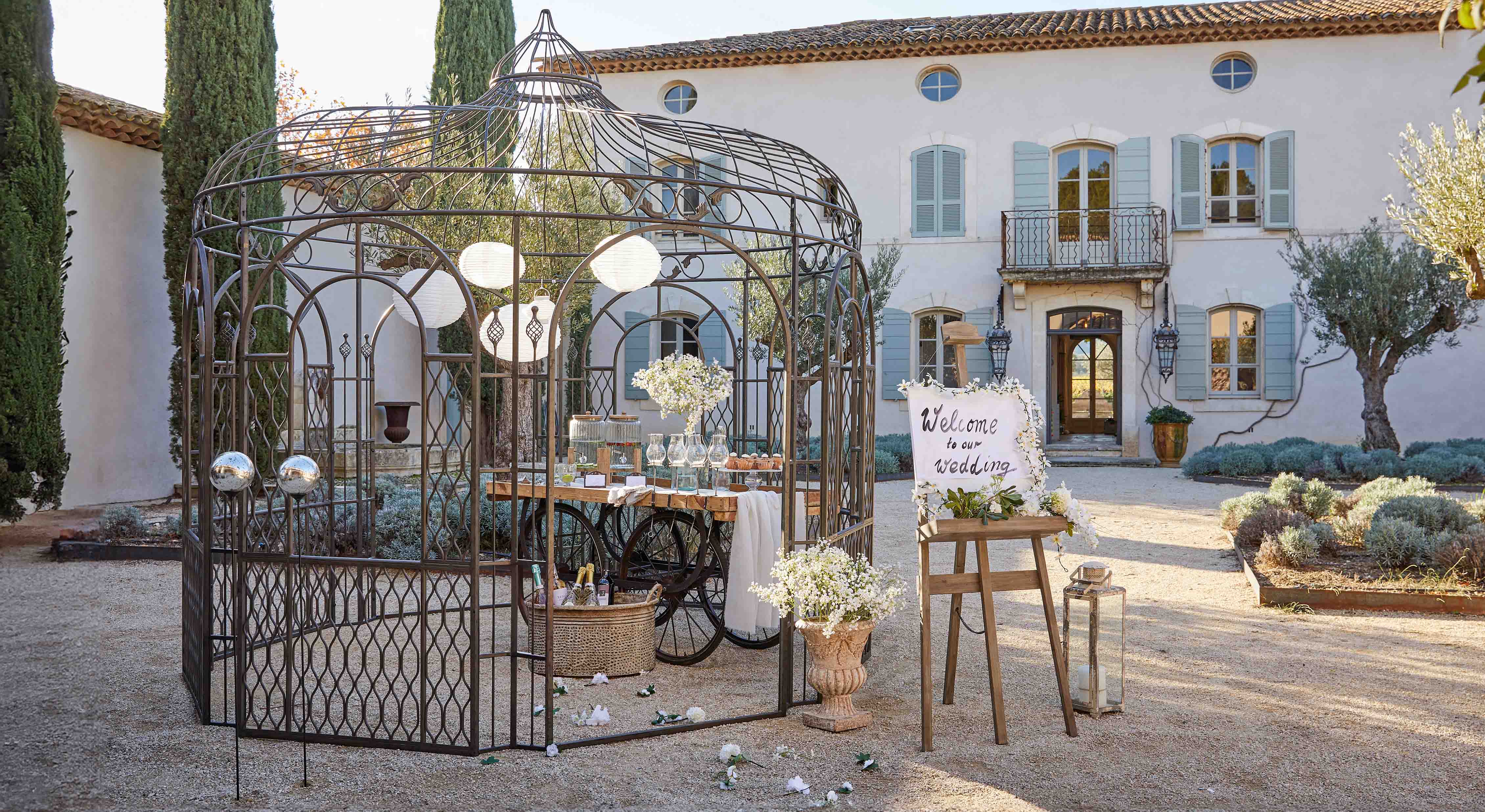 Metallpavillon mit dekorativem Muster im Garten mit Tisch und Blumen für Hochzeitsfeier