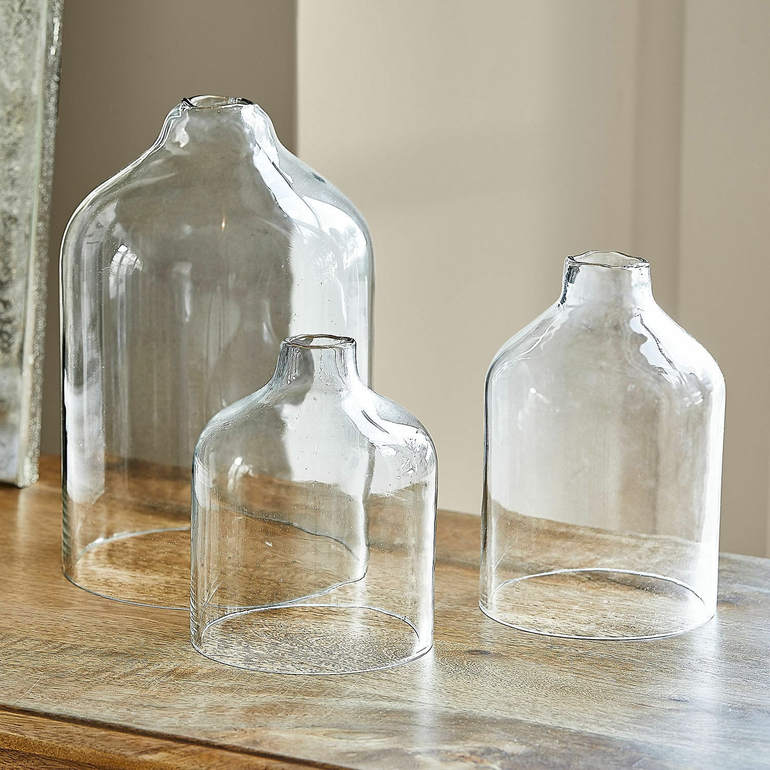 Windlicht 3er Set Xalvent Set aus drei transparenten Glasvasen in verschiedenen Grössen auf einem Holztisch