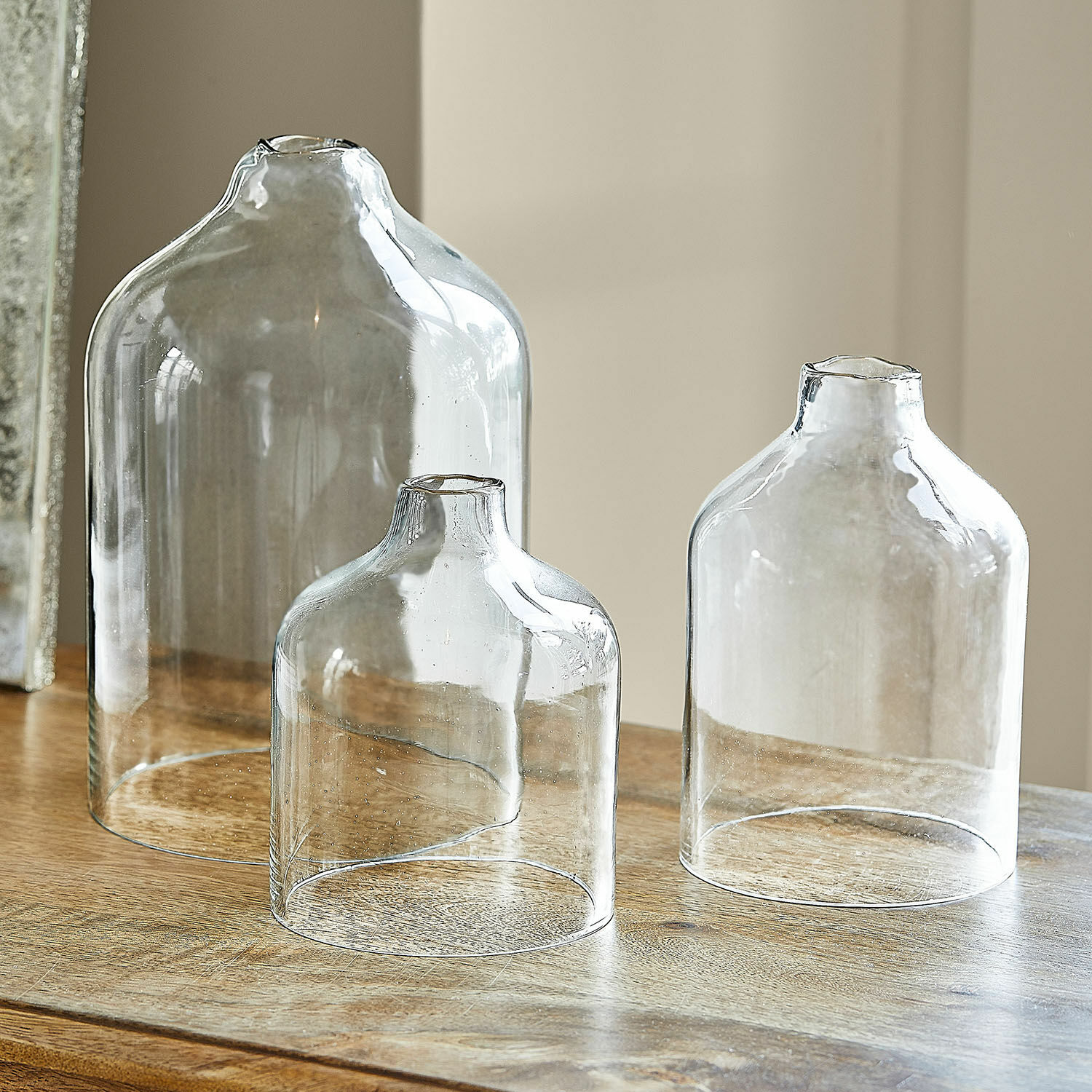 Windlicht 3er Set Xalvent Set aus drei transparenten Glasvasen in verschiedenen Grössen auf einem Holztisch