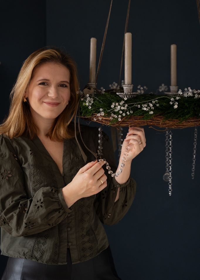 Grüner Adventskranz mit weissen Kerzen und Kristalldekorationen, hängend an Bändern