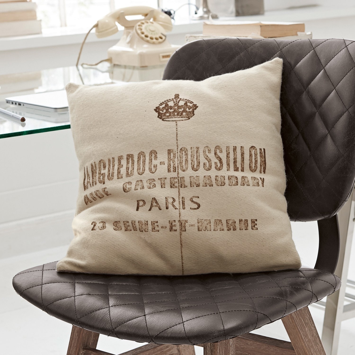 Kissen Roussilion Beiges Dekokissen mit Languedoc-Roussillon-Aufdruck auf schwarzem, gestepptem Lederstuhl