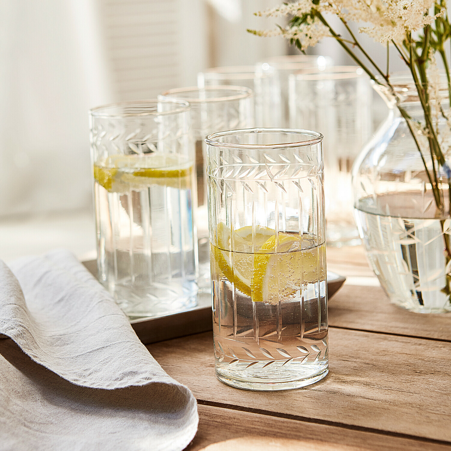 Glas 6er Set Padiès Gläser aus klarem Glas mit graviertem Blattmuster, gefüllt mit Zitronenwasser auf Holztisch