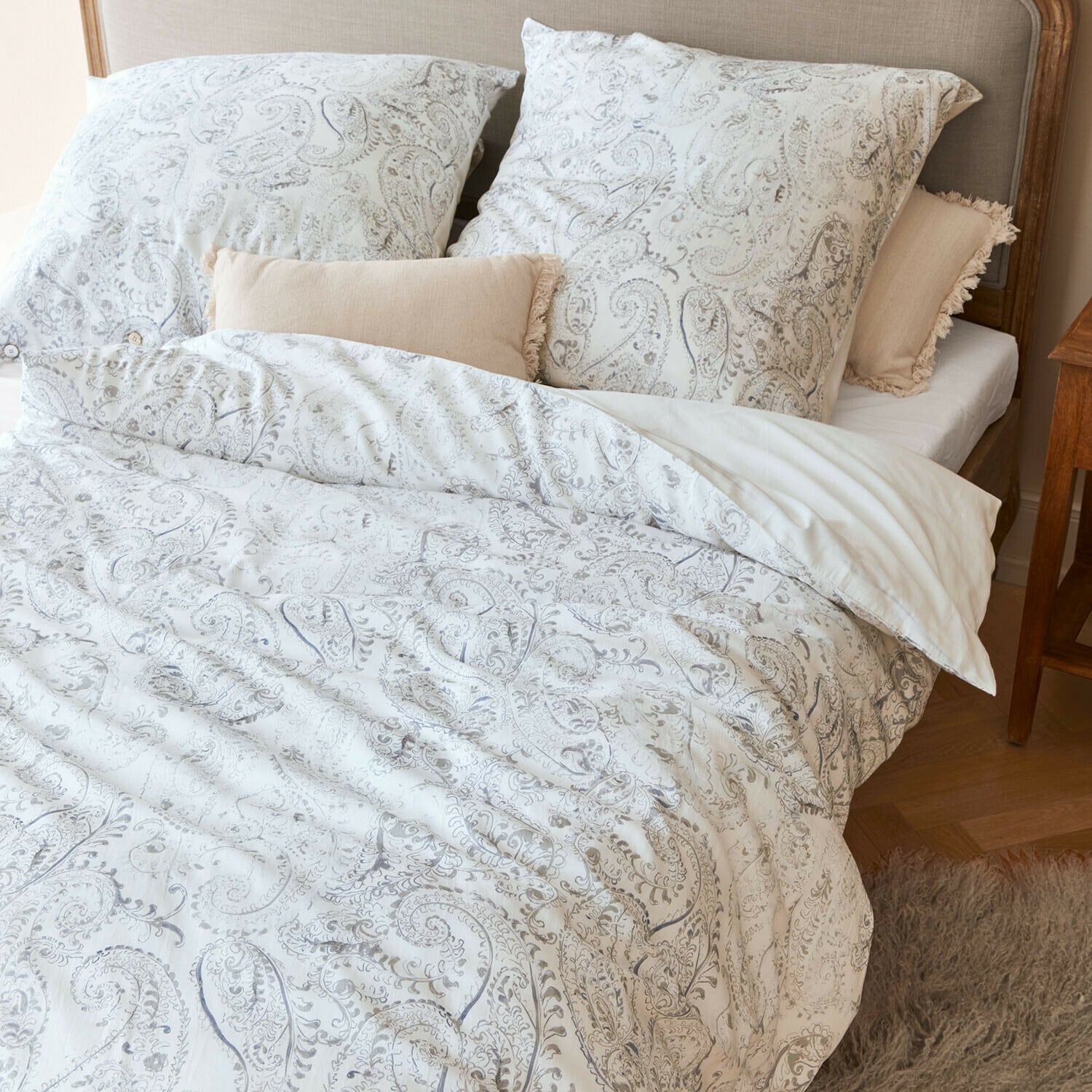 Bettwäsche Caselia Baumwoll-Bettwäsche mit hellem Paisley-Muster auf Bett mit beigen Dekokissen