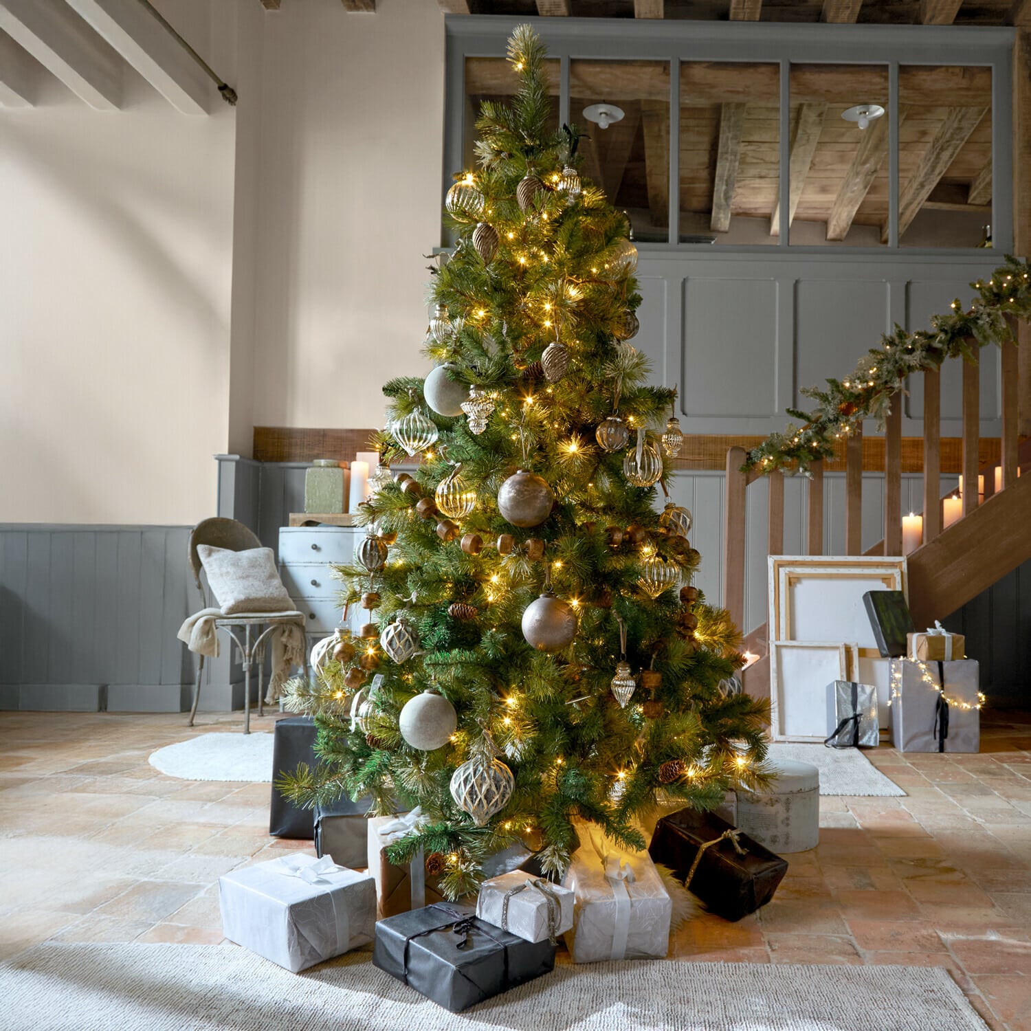 Weihnachtsbaum Aure Weihnachtsbaum mit grünen Zweigen und goldenen Lichtern geschmückt in gemütlichem Raum mit Geschenken