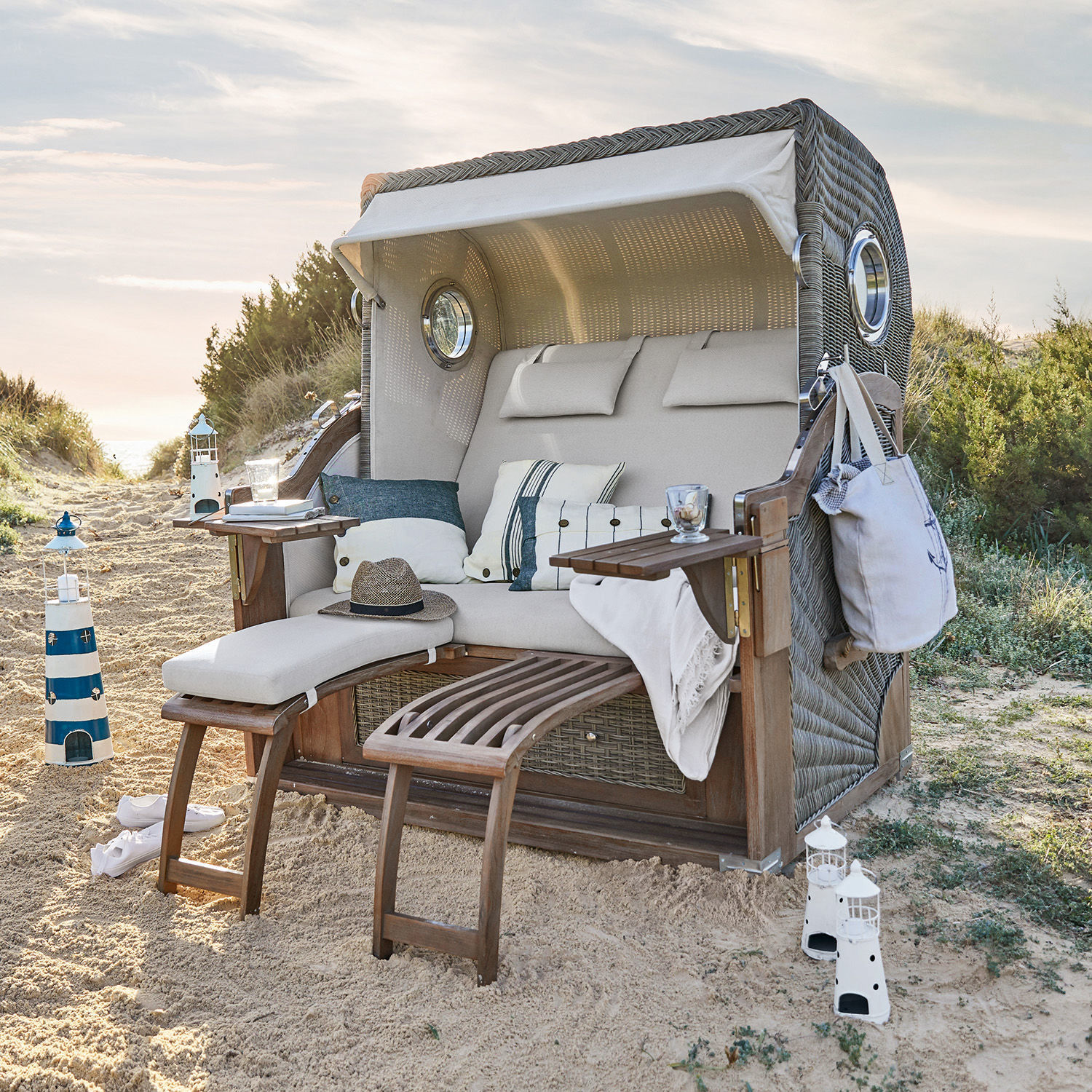 Strandkorb Clifford Beach Strandkorb aus Geflecht mit beigem Polster und Holzfussstützen im Sand, Gartenmöbel