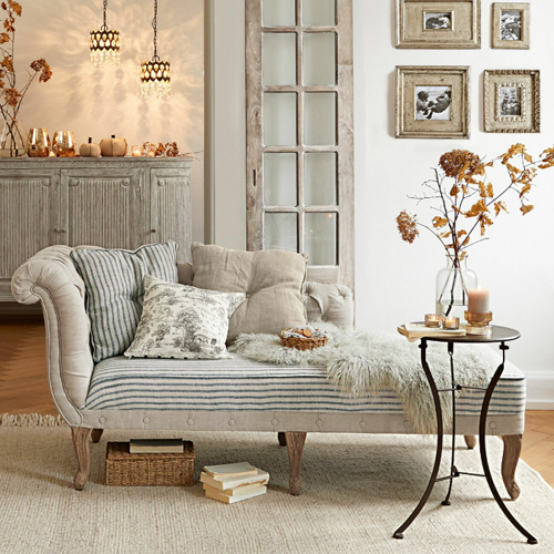 Beige gepolsterte Chaiselongue mit Kissen und Metalltisch in gemütlichem Wohnzimmer mit Dekoration