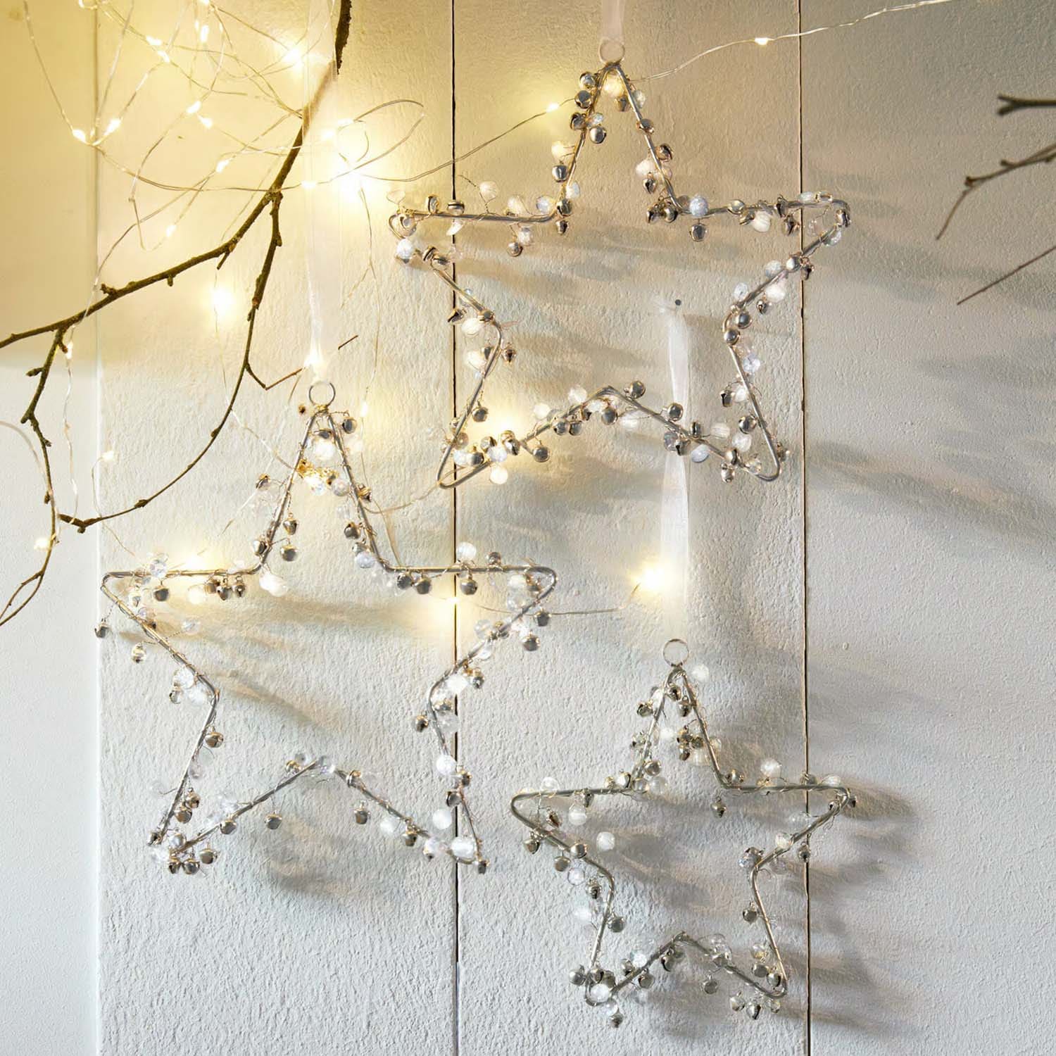 Dekorative Metallsterne mit Glöckchen und LED-Lichtern für festliche Innenraumgestaltung