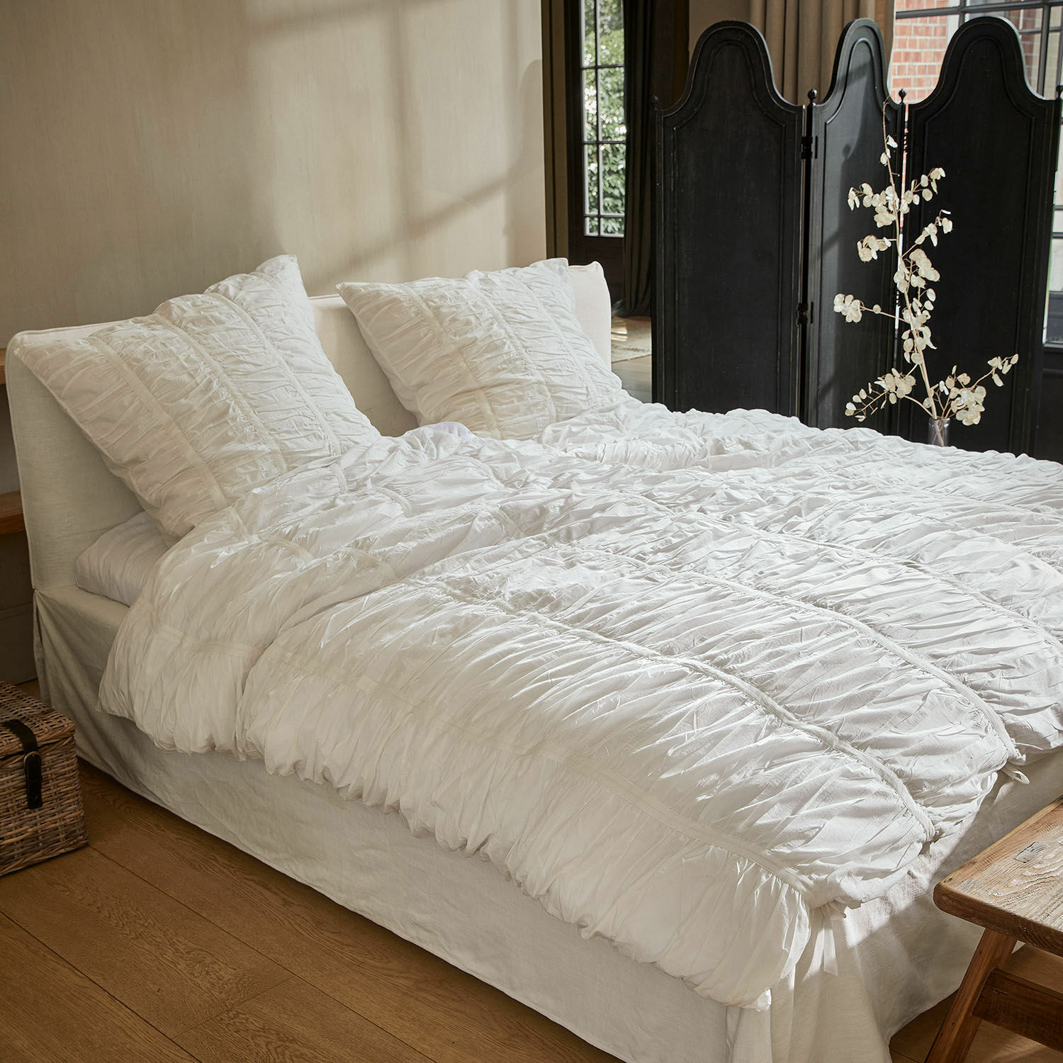 Bettwäsche Magdelen Weisse Baumwollbettwäsche mit Rüschen auf dem Bett in einem gemütlichen Schlafzimmer