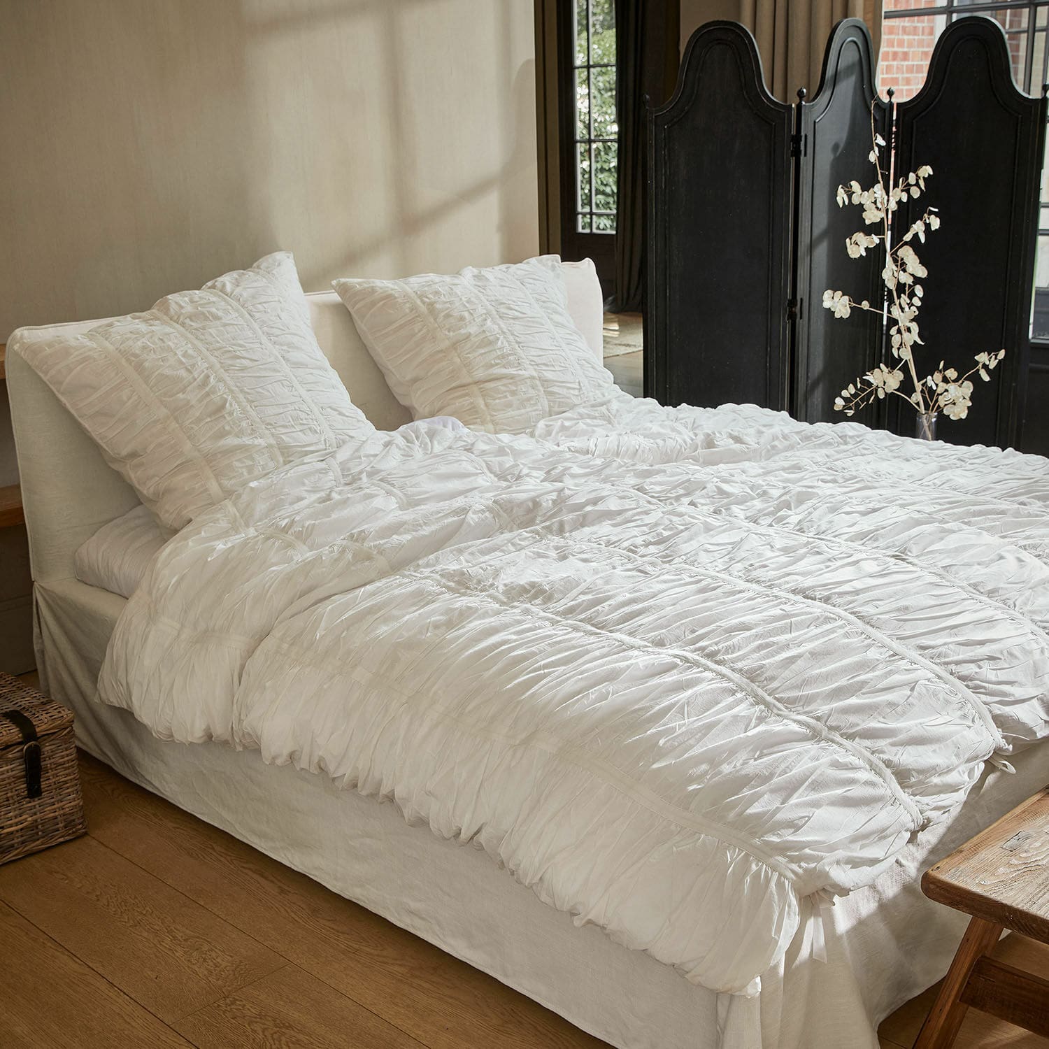 Bettwäsche Magdelen Weisse Baumwollbettwäsche mit Rüschen auf dem Bett in einem gemütlichen Schlafzimmer