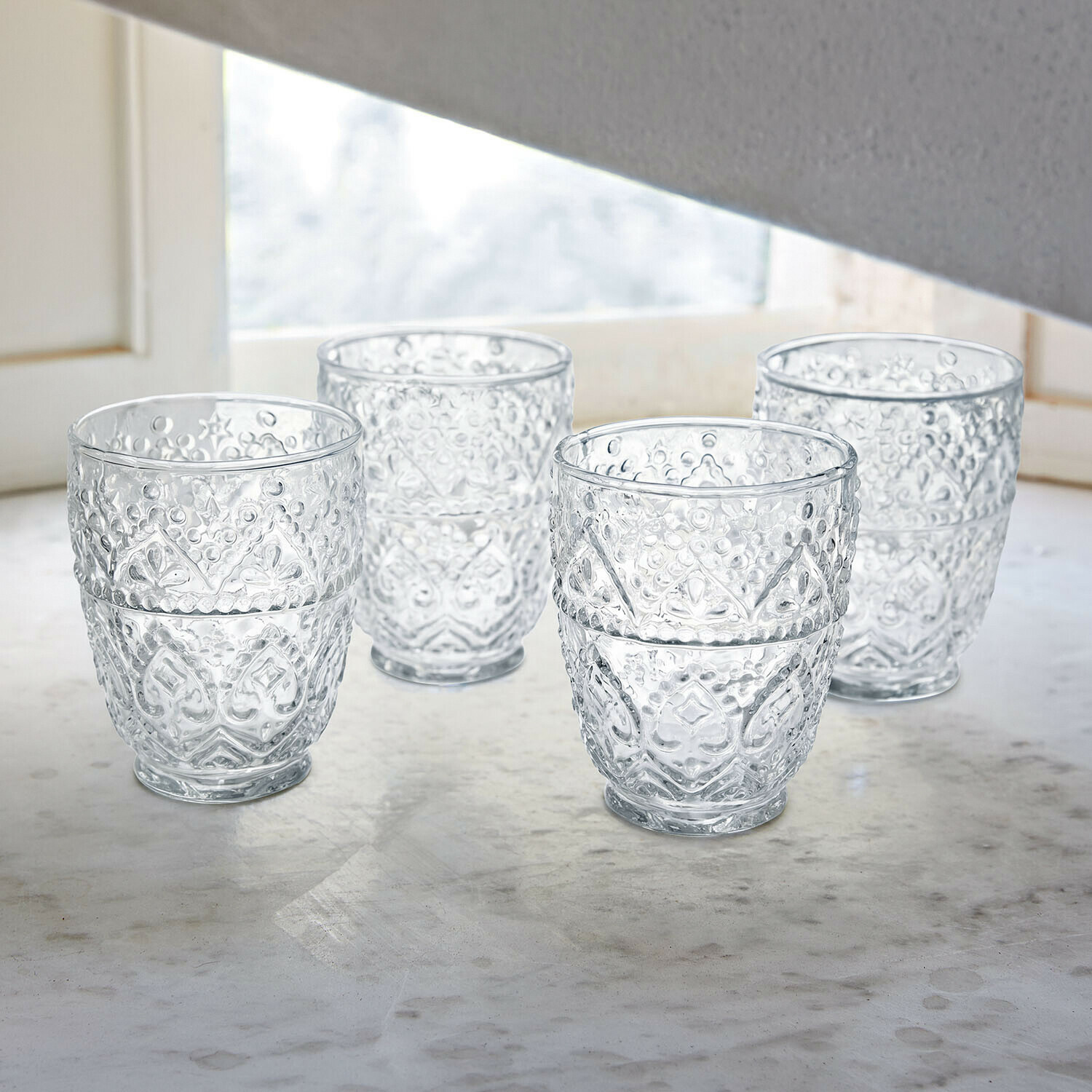 Glas 4er Set Rivoux Gläser mit Rotwein und Flasche auf weissem Tisch mit dekorativen Metalllampen im Garten