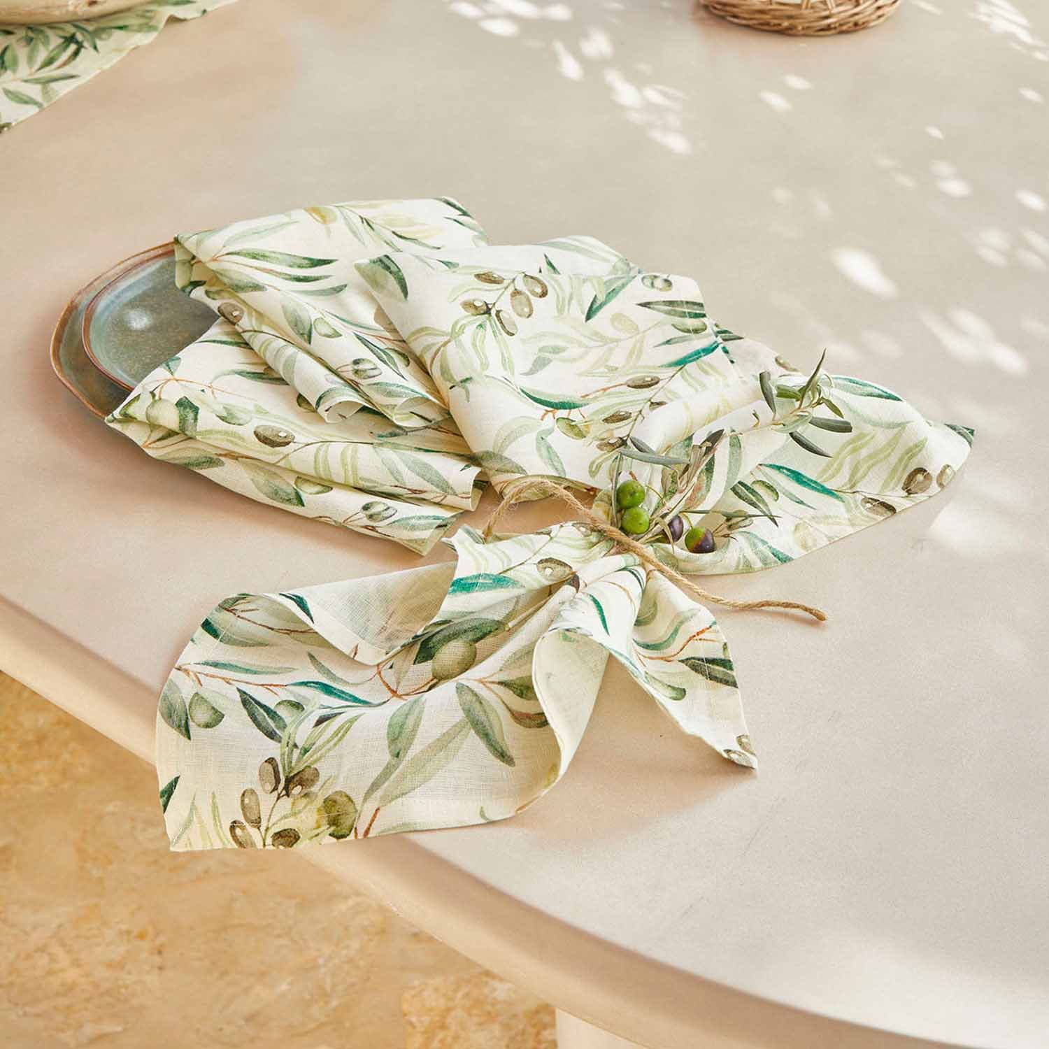 Leinenservietten in Creme mit grünem Olivenmuster auf Tisch, elegante Tischdekoration