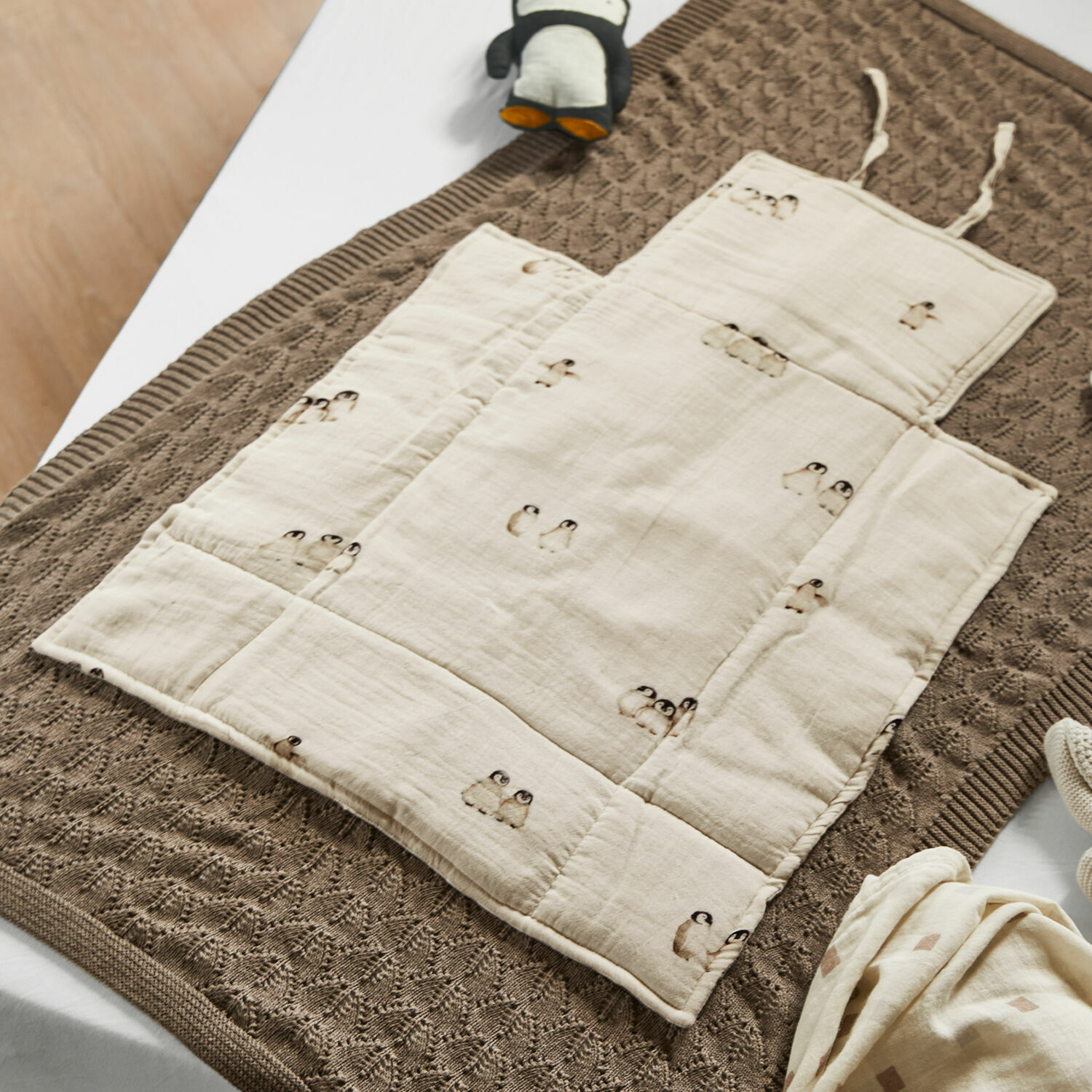 Wickelunterlage Jocienne Beige Baumwoll-Krabbeldecke für Kinder mit Pinguin-Motiv auf brauner Strickdecke, Babyzubehör