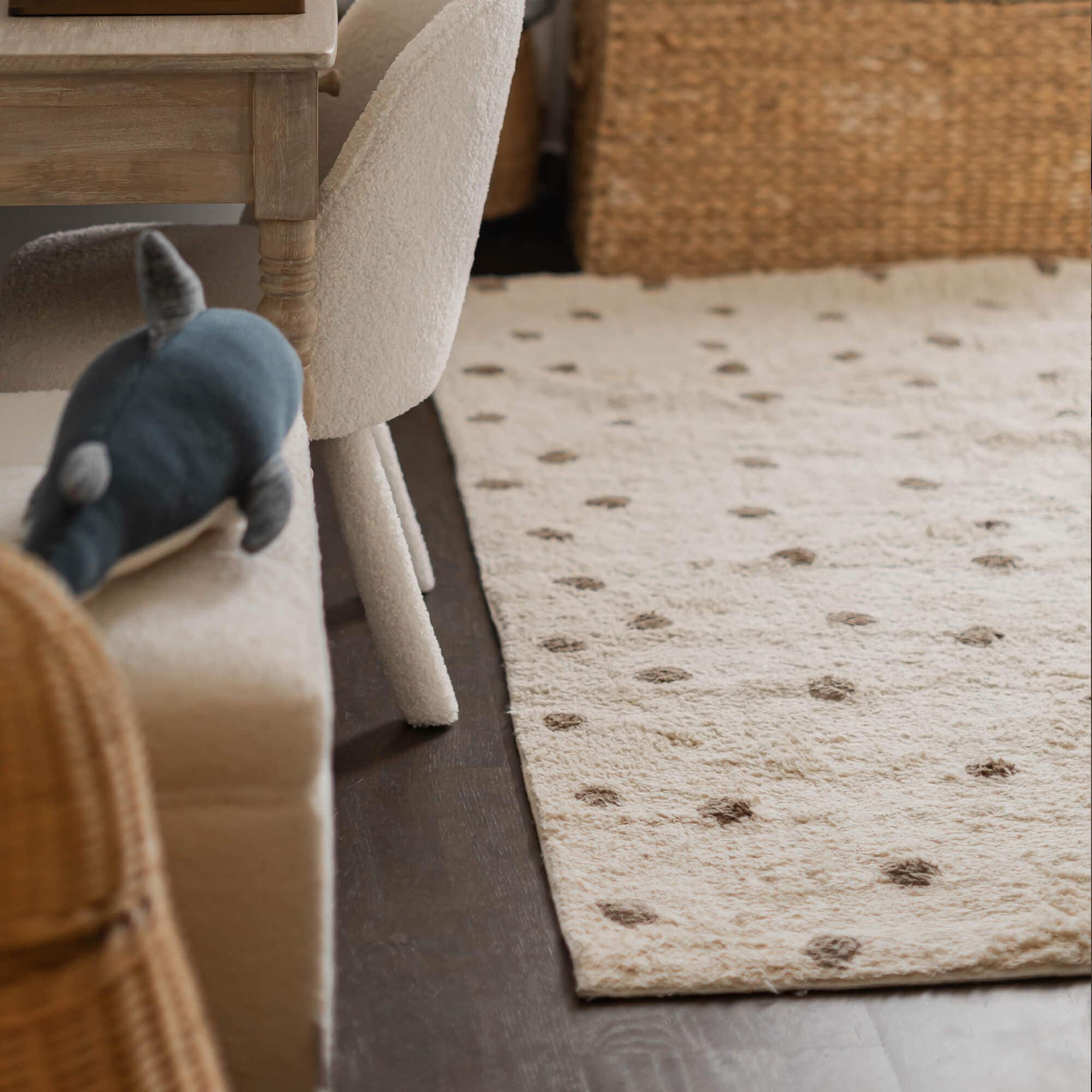 Beiger Teppich aus weichem Material mit braunen Punkten auf dunklem Untergrund im Wohnzimmer