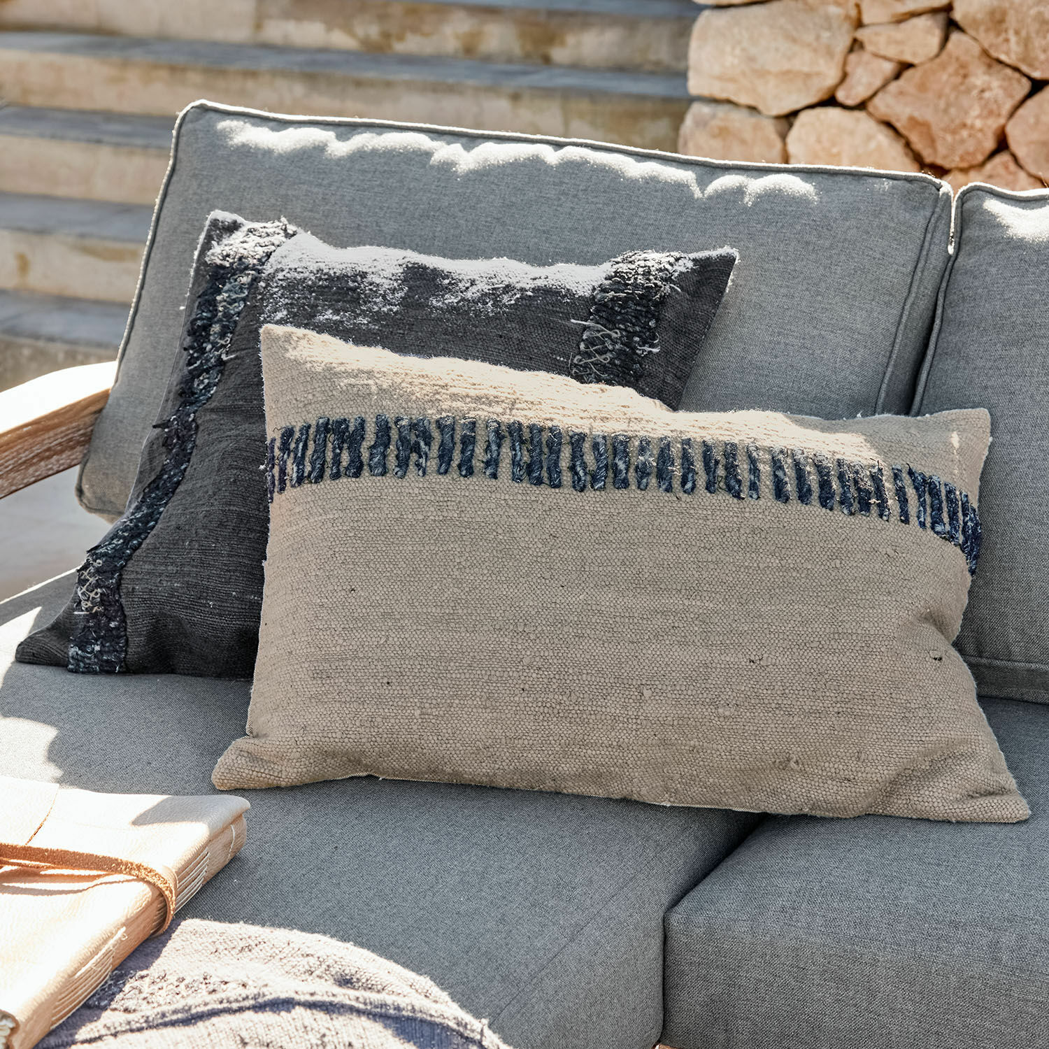 Kissenhülle 2er Set Foix Beige und schwarze dekorative Kissen aus Stoff auf grauem Sofa im Aussenbereich, Wohntextilien