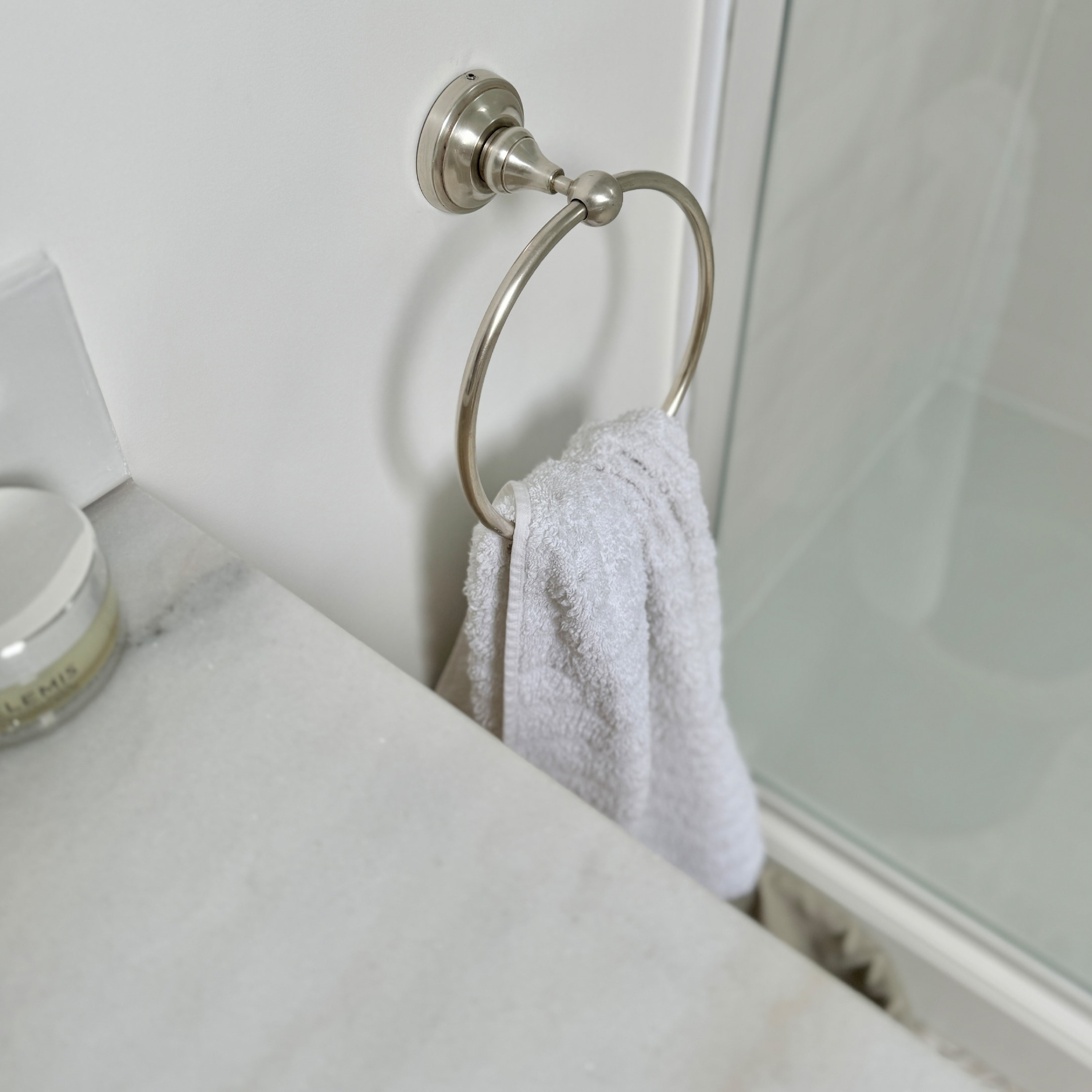 Metall-Handtuchhalter mit weissem Handtuch und Marmorarbeitsplatte im Badezimmer