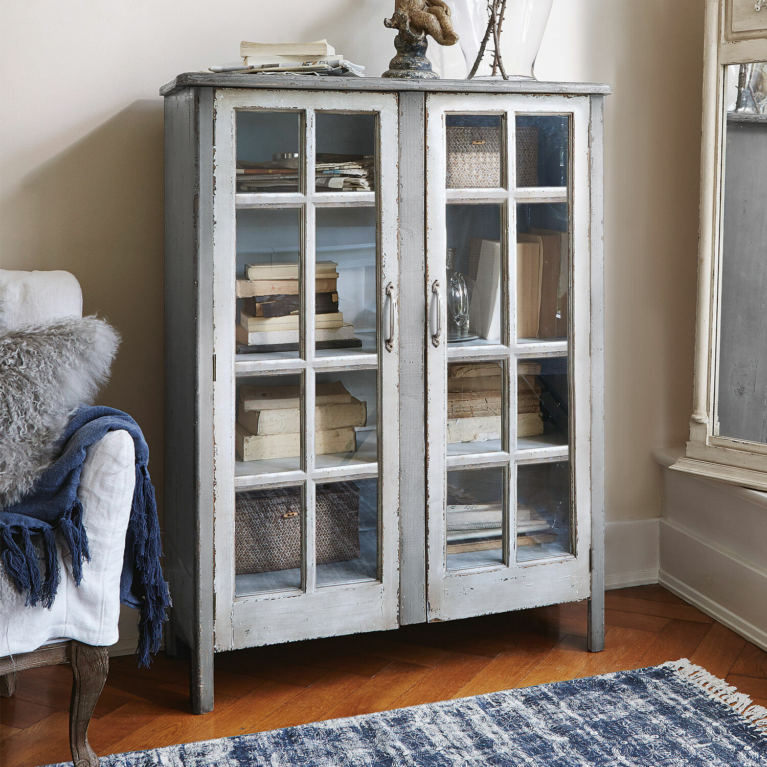 Kommode Sherman Grauer Holzvitrinenschrank mit Glastüren und antikem Vintage-Finish im Wohnzimmer