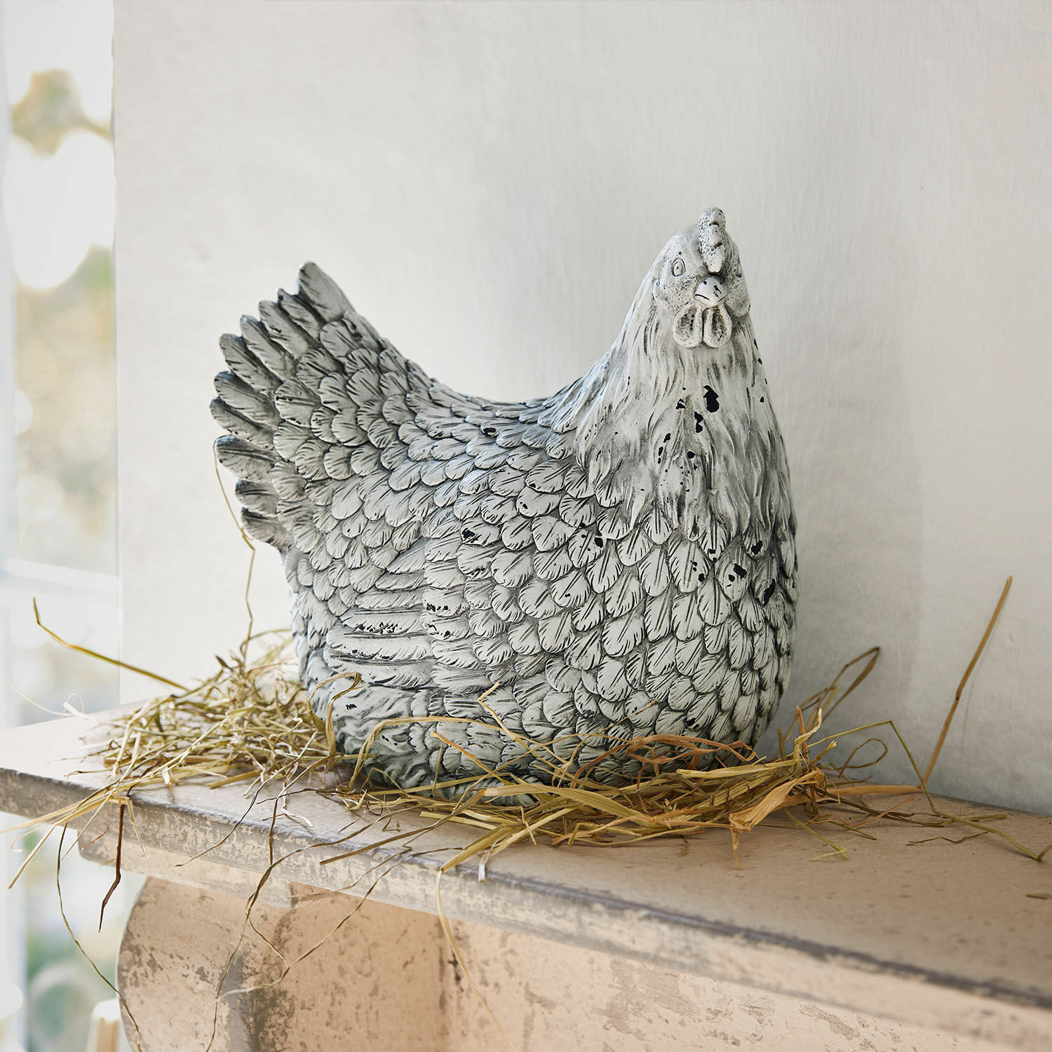 Deko-Huhn Delmonico Dekorative Hühnerfigur aus grauweissem Material auf Stroh, Wohn- und Gartendekoration