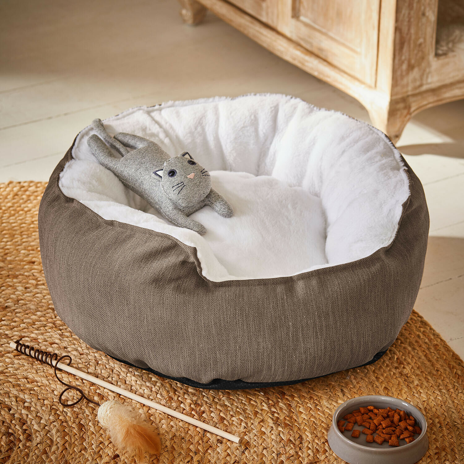 Haustierbett Camérelle Braunes Katzenbett mit weissem, weichem Innenfutter und grauem Katzenspielzeug darauf