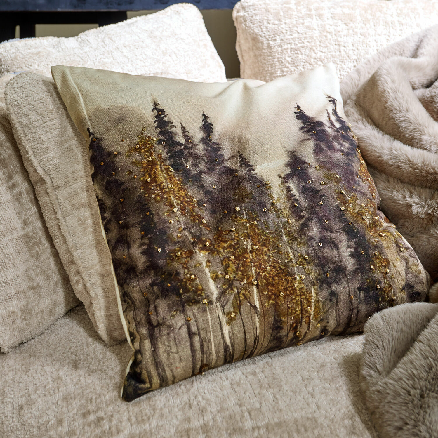 Kissenhülle Aurignac Dekoratives Kissen mit Waldmotiv und goldenen Pailletten auf beigem Stoff auf dem Sofa