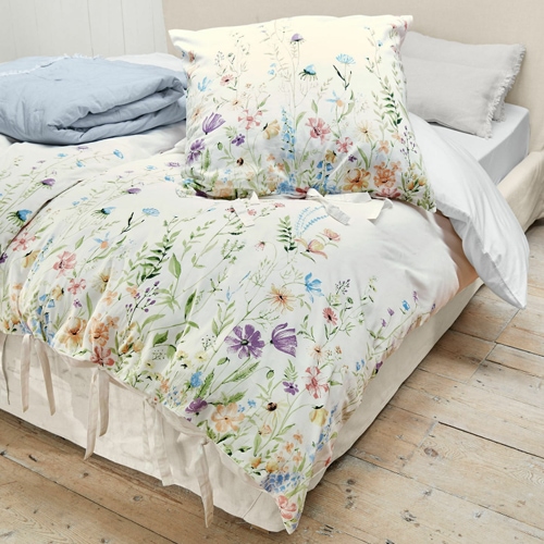 Baumwollbettwäsche mit buntem Blumenmuster auf hellem Grund, zart und dekorativ fürs Schlafzimmer