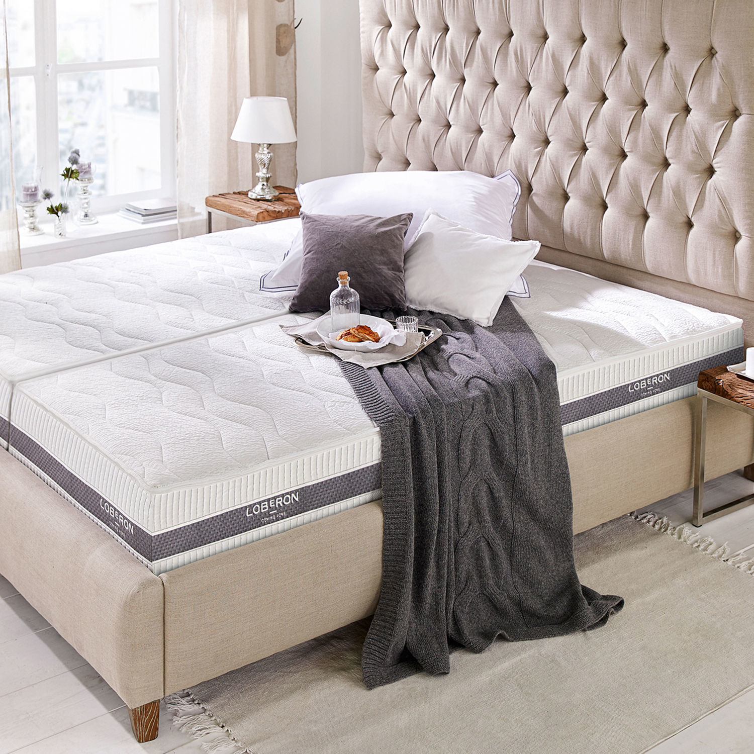 Matratze 90x200 Sevilha Beiges Polsterbett mit weisser Loberon-Matratze, grauer Decke und Kissen in hellem Schlafzimmer