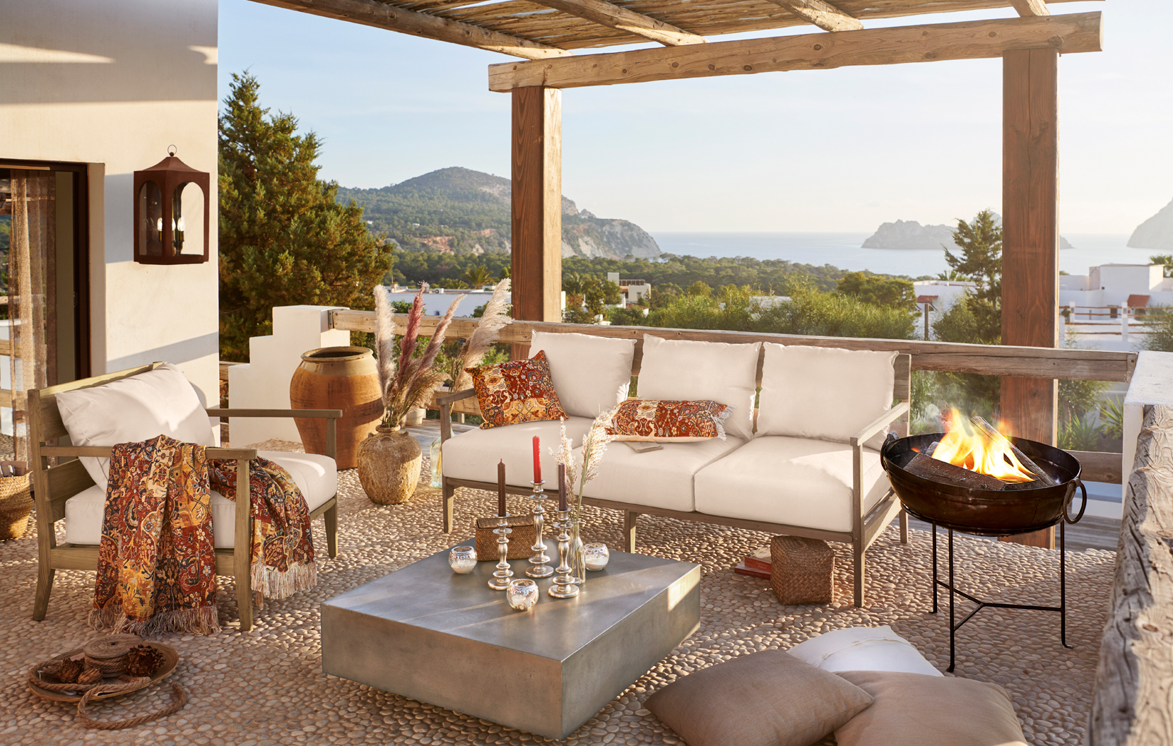 Gemütliche Terrasse mit beigen Polstern und orientalischen Akzenten mit Blick auf Meer und Berge