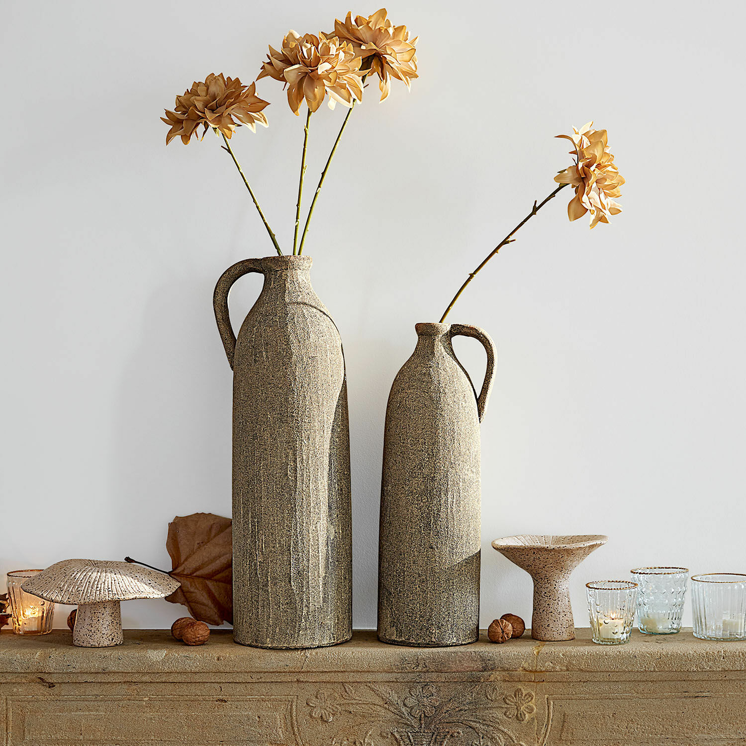 Vase 2er Set Kalidaan Zwei hohe beigen Keramikvasen mit getrockneten Blumen und Dekorationen auf einer steinernen Ablage
