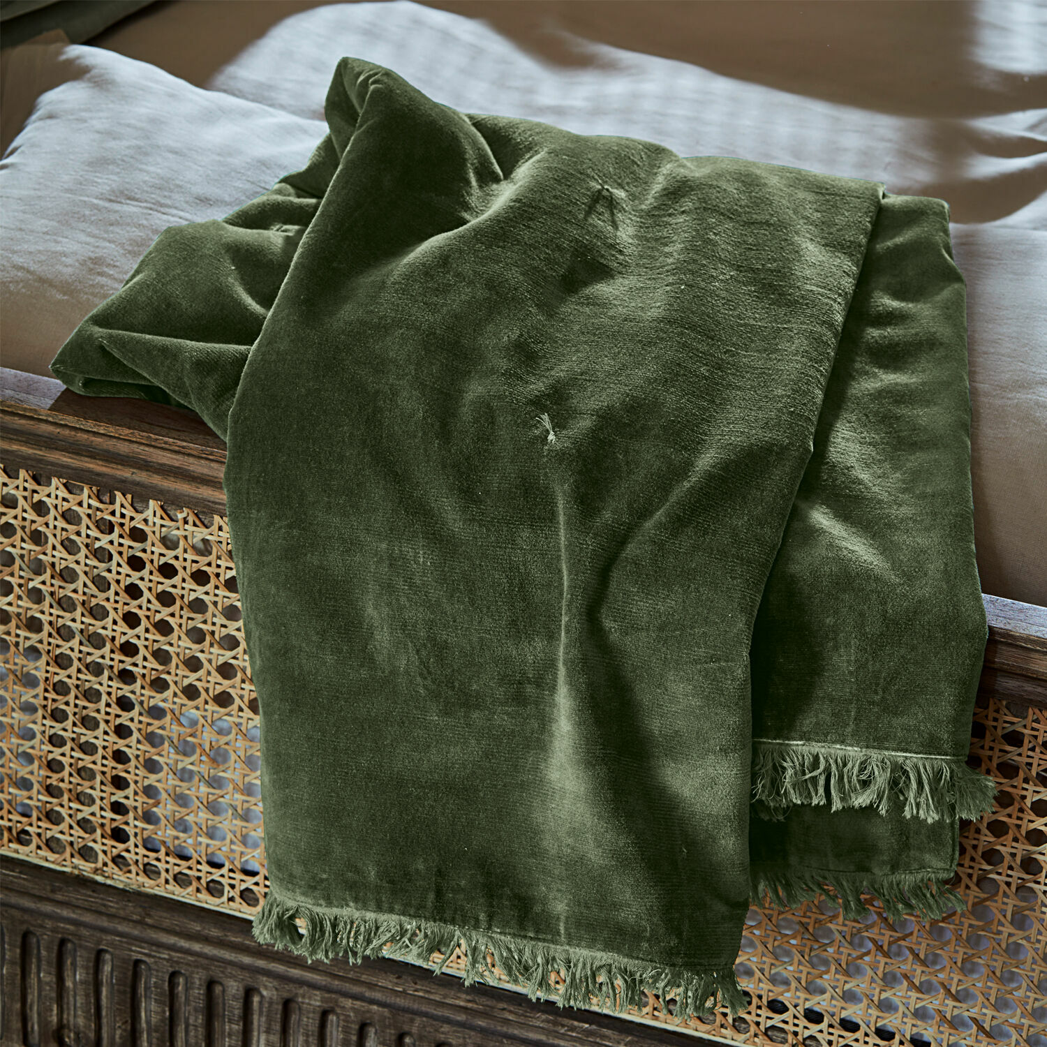 Plaid Maelis Grüne Samtdecke mit Fransen auf Holzbett, weiches dekoratives Wohntextil für das Schlafzimmer