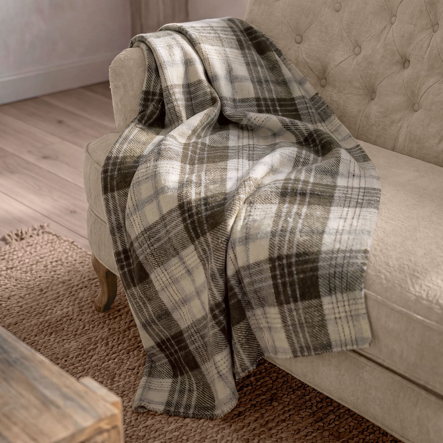 Weiche kariert Decke in Beige- und Brauntönen auf beigem Sofa im Wohnzimmer