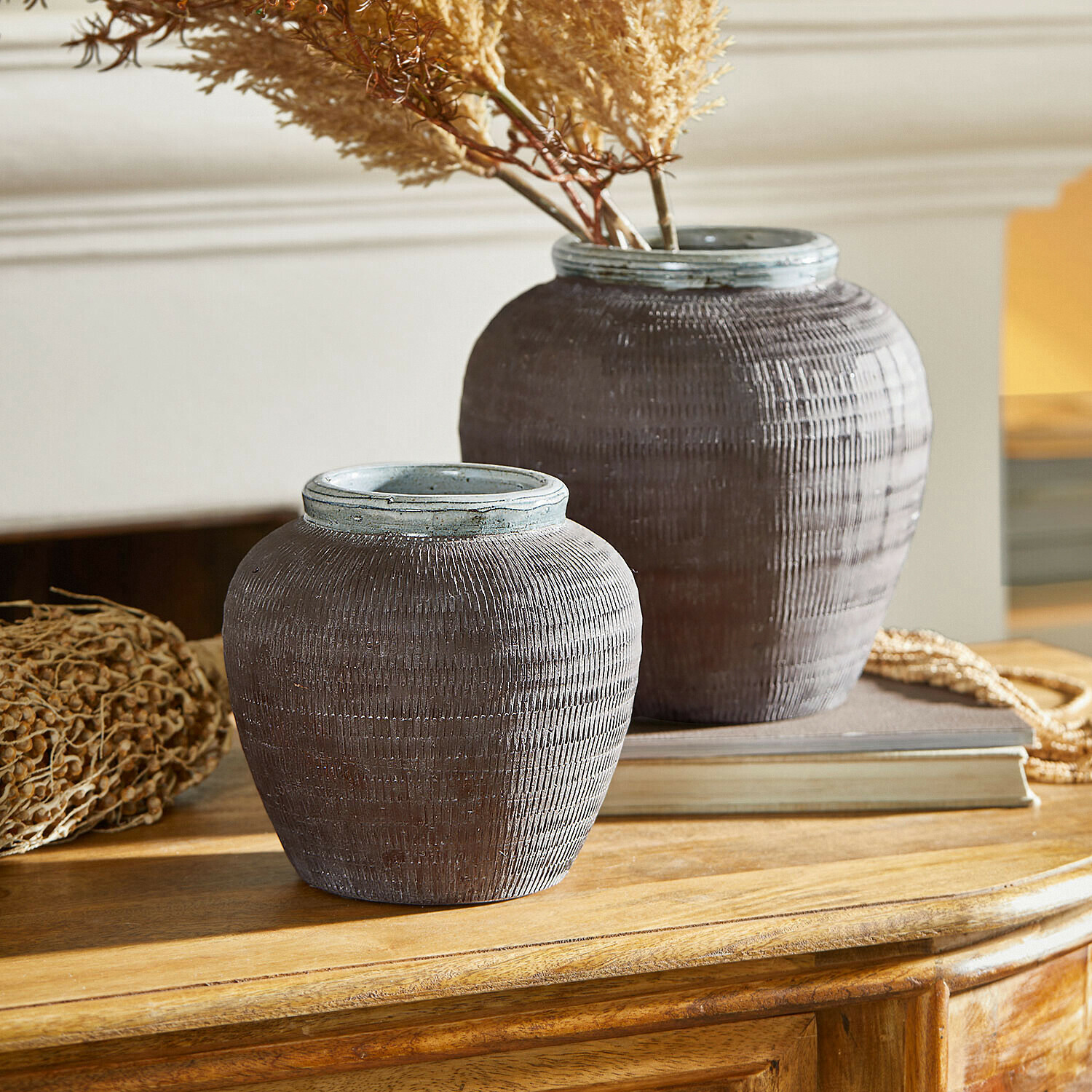 Vase 2er Set Calverna Zwei dekorative braune Keramikvasen auf Holztisch mit getrockneten Pflanzen als Dekoration