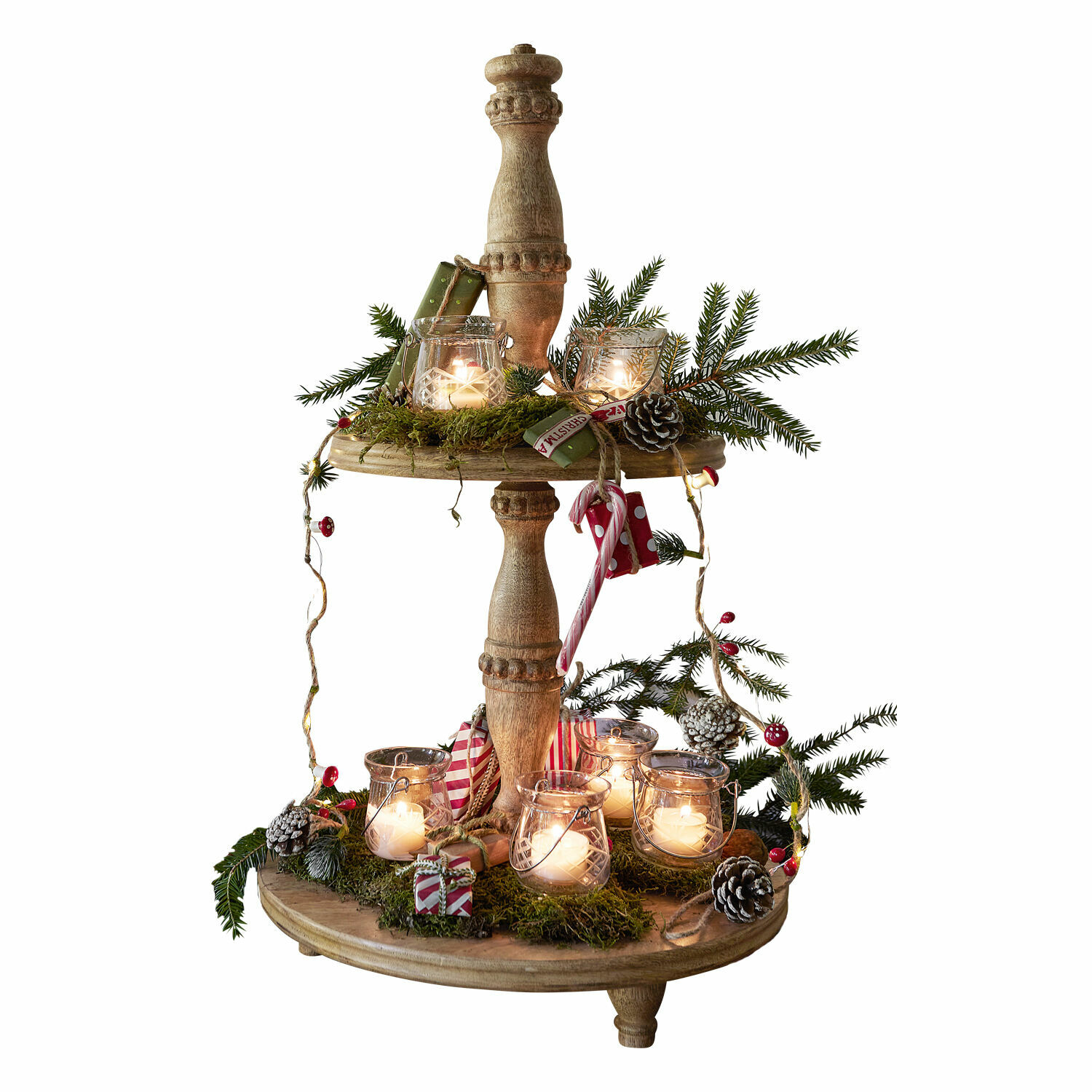 Zweistöckige Weihnachtsdekoration aus Holz mit Laternen, grünen Zweigen und festlichen Ornamenten beleuchtet