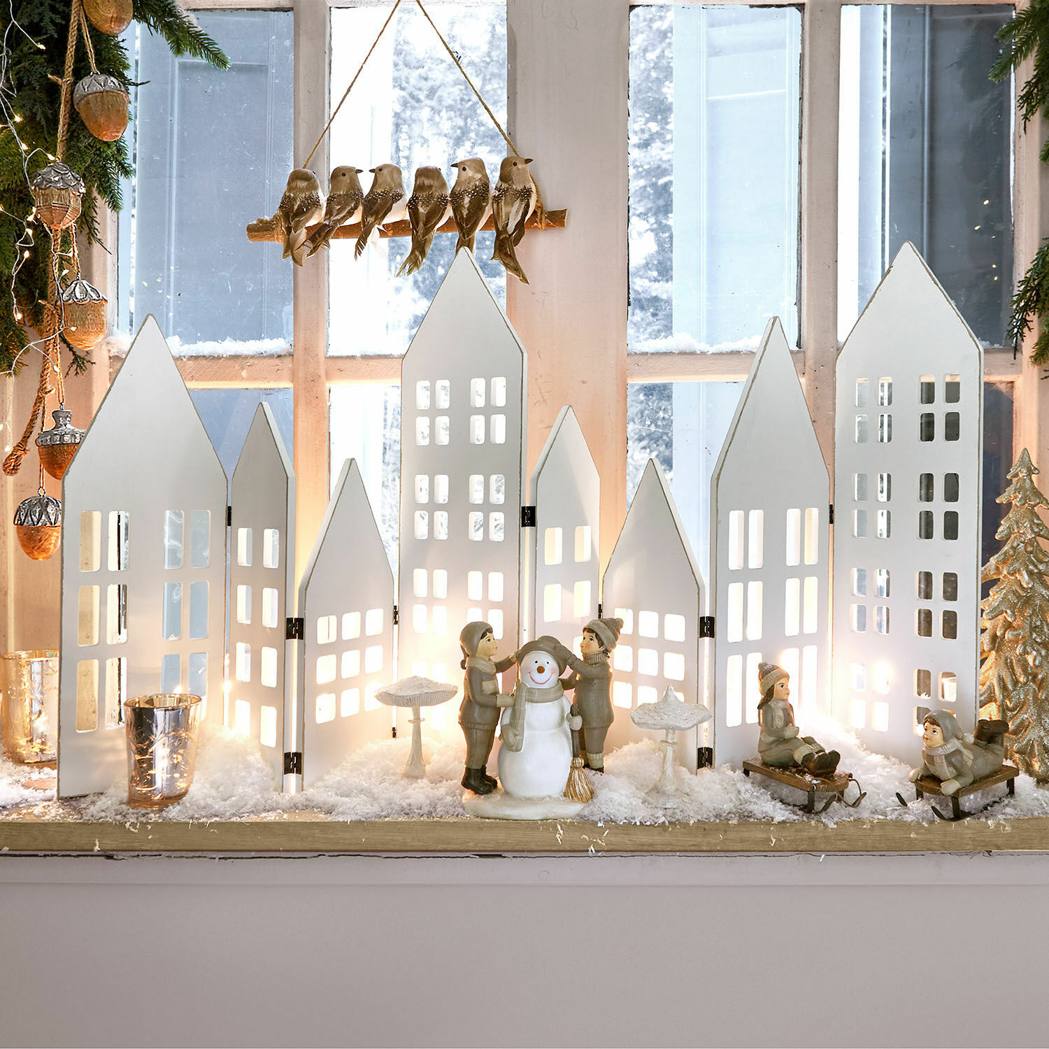 Deko-Shutter Cottages Winterliche Dekoration mit weissen Holz-Häusern und Kinderfiguren mit Schneemann auf der Fensterbank