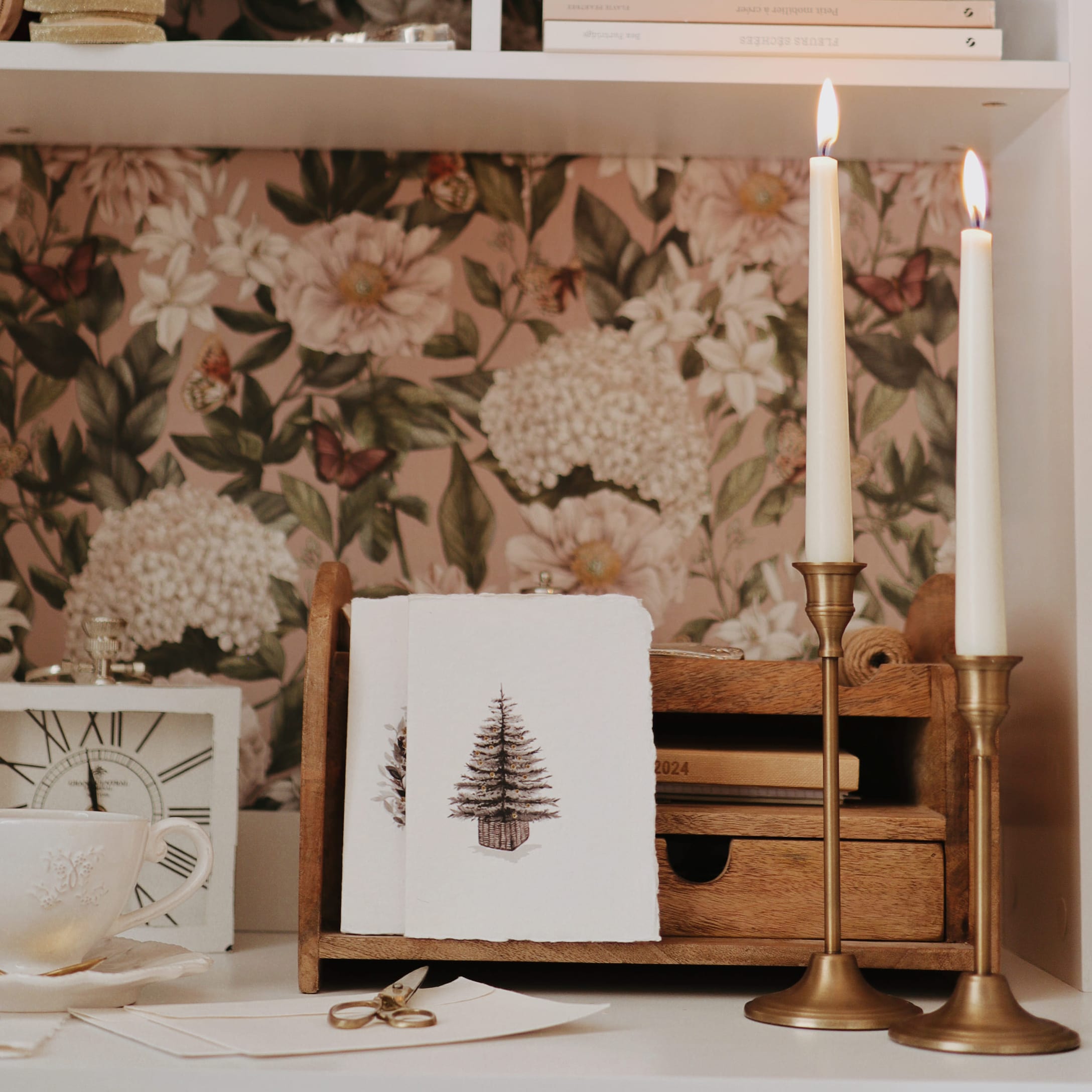 Holz-Organizer mit Weihnachtskarten und zwei goldenen Kerzenhaltern auf weissem Hintergrund