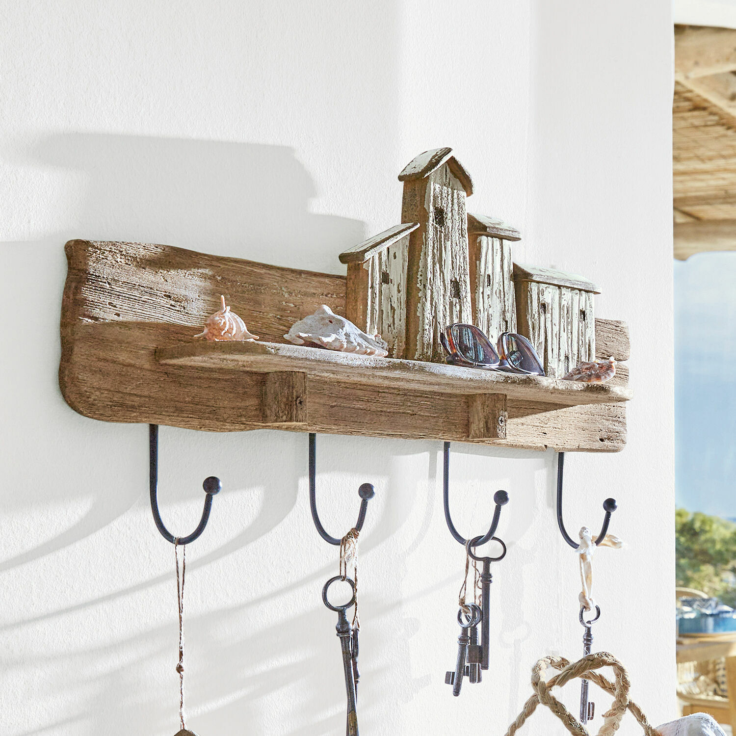 Hakenboard Charmani Rustikaler Wandhaken aus Holz und Metall mit Häuschen-Dekor und Haken für Schlüssel und Brillen.