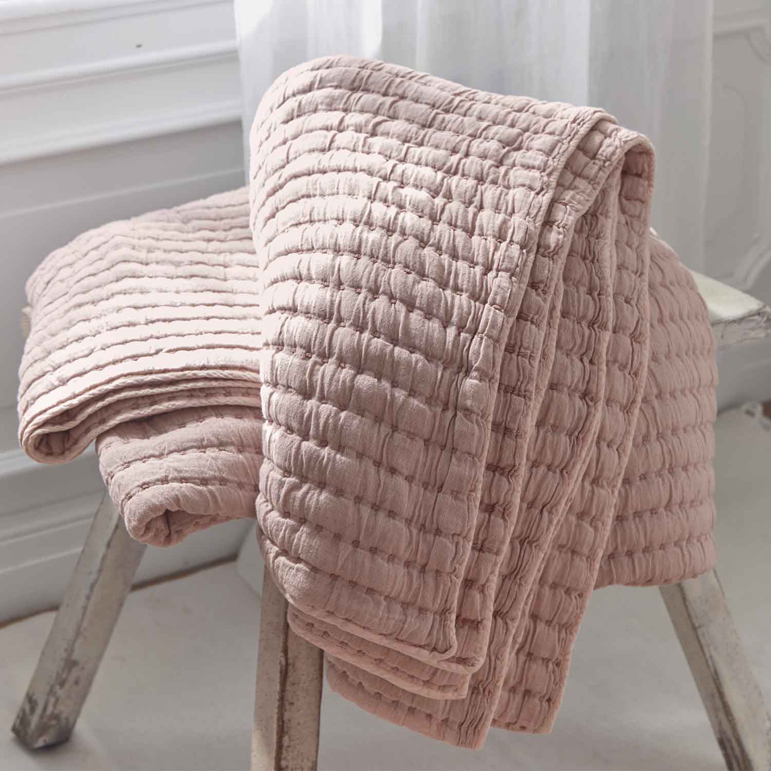 Weiche rosa Baumwolldecke mit wabenartiger Steppstruktur, ideal für gemütliche Wohnräume