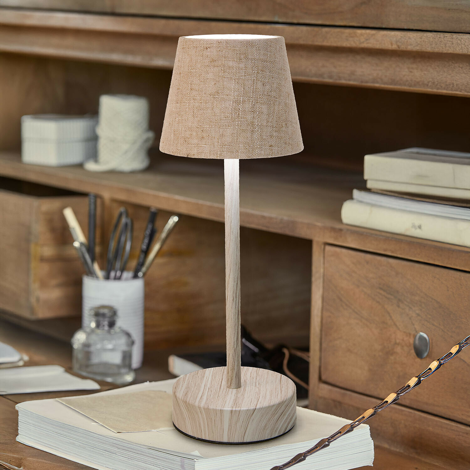 Wiederaufladbare Tischlampe Sylvainie Tischlampe mit beigem Stoffschirm und Holzfuss auf Schreibtisch mit Büchern und Schreibutensilien