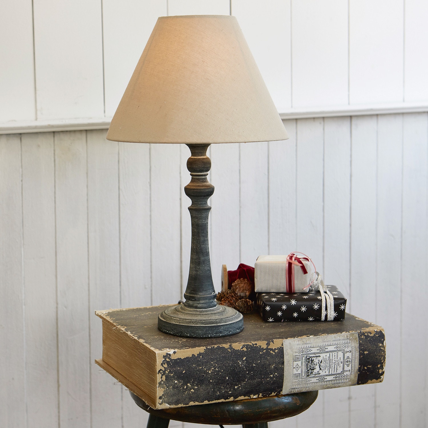 Tischlampe Withby Tischlampe mit beigem Schirm und antikem schwarzem Sockel vor weisser Wand