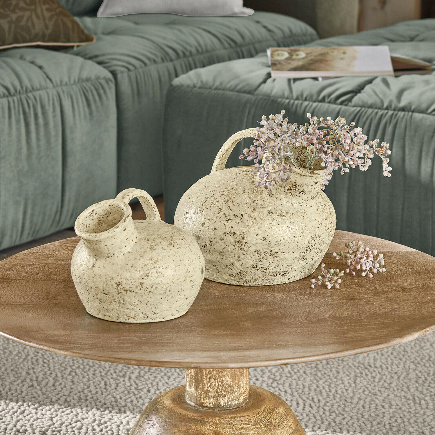 Vase 2er Set Gravière Zwei cremefarbene Keramikvasen mit Griffen auf Holztisch vor grünem Sofa im Wohnzimmer