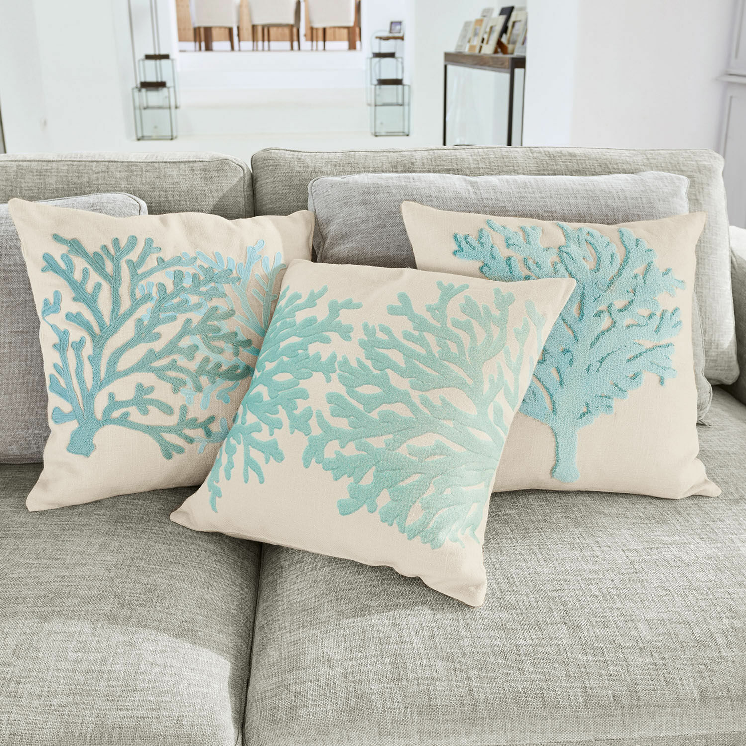 Kissenhülle 3er Set Vaiea Beige Dekokissen mit blauem Korallen-Stickmuster auf grauem Sofa im Wohnzimmer