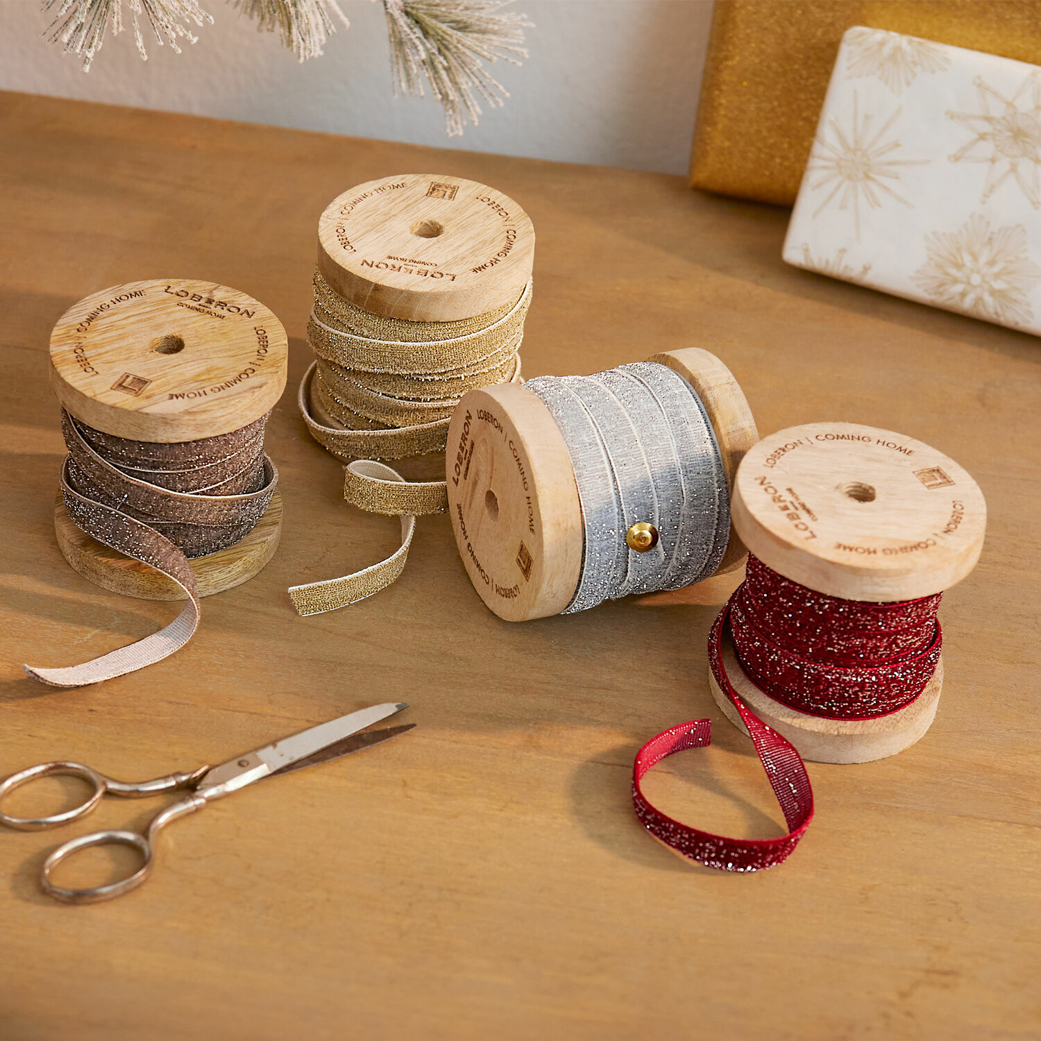 Samtband 4er Set Verlanne Vier dekorative Glitzerbänder auf Holzspulen in verschiedenen Farben zum festlichen Verpacken von Geschenken.
