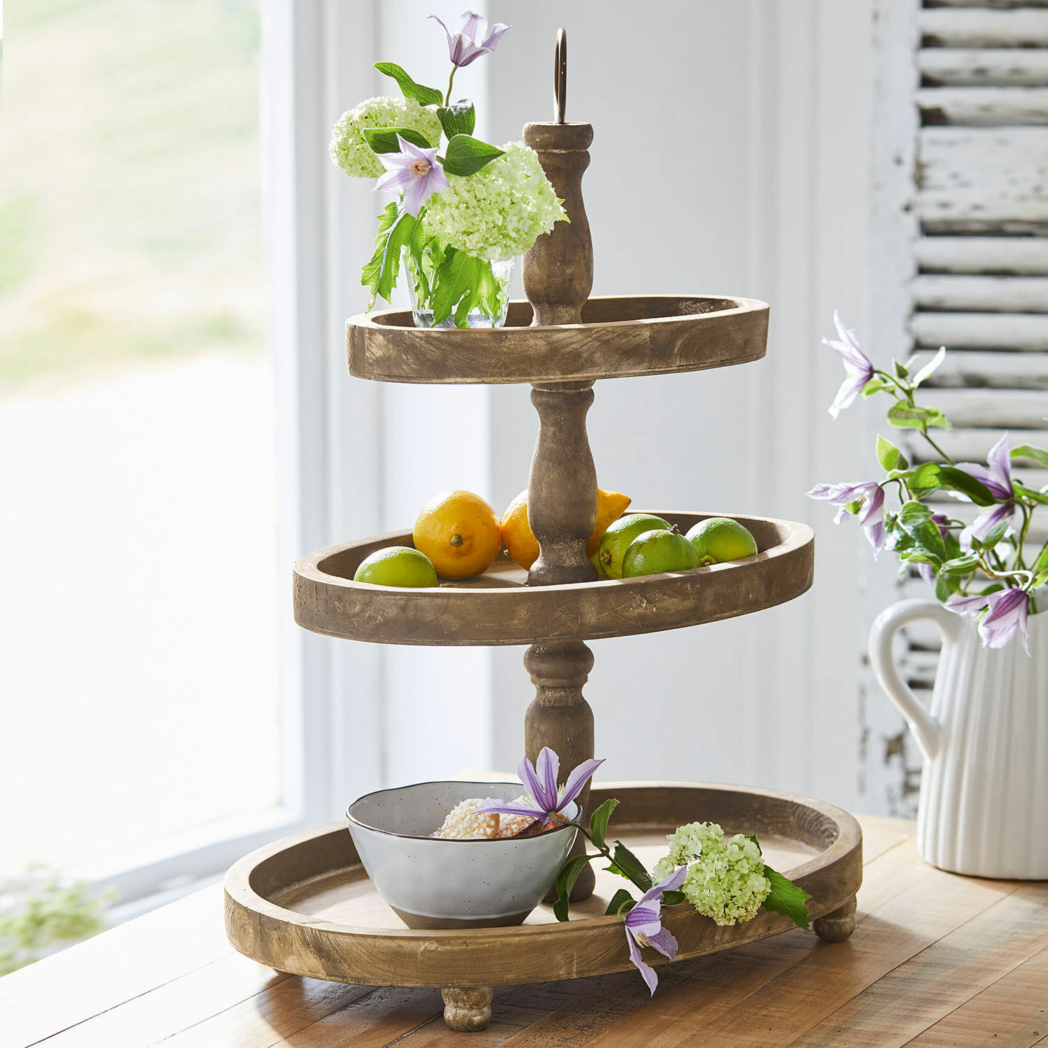Etagere Olathe Dreistöckiges Holzetagere mit Früchten und Blumen auf Holztisch in hellem Raum