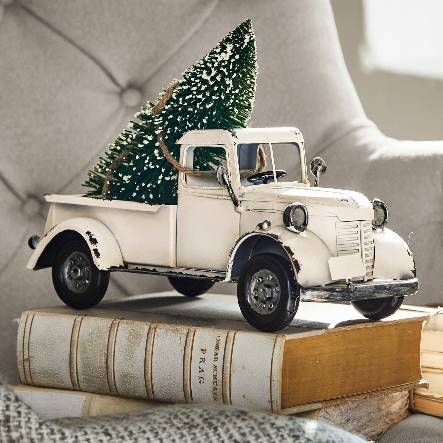 Deko-Auto Formis Weisses Metallmodell eines alten Lastwagens mit grünem Tannenbaum auf Büchern, Weihnachtsdekoration