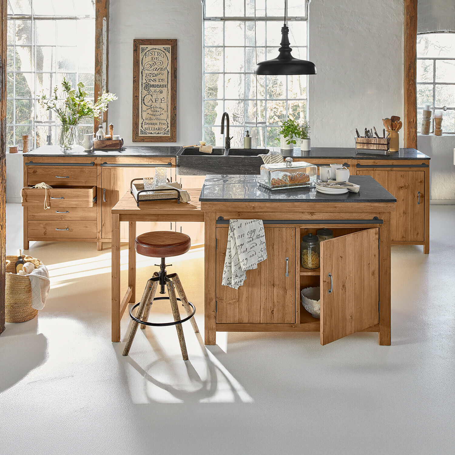 Küche mit Holzschränken und schwarzer Arbeitsplatte, Barhocker und Dekorationen im Licht